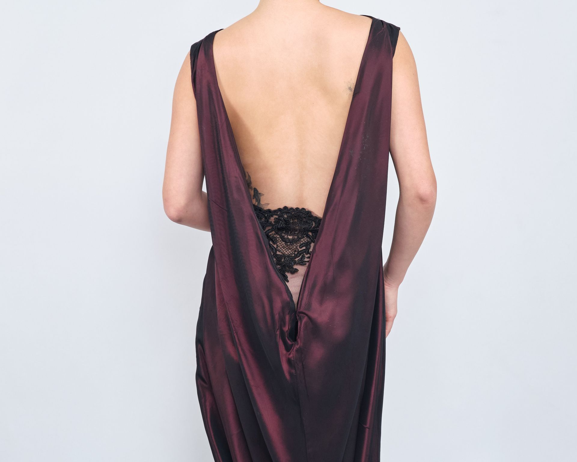 The back of a woman wearing a purple dress with a v-neck