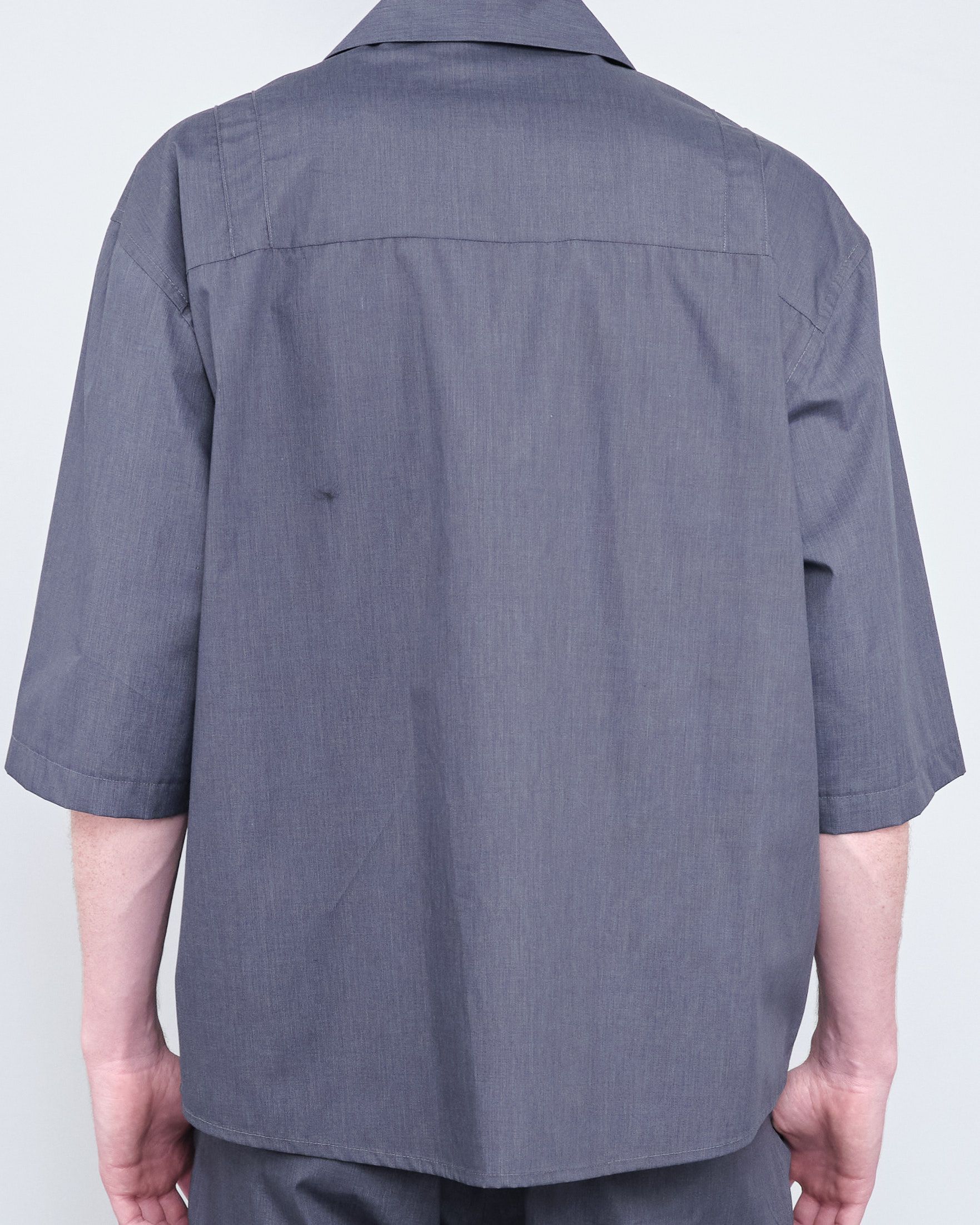 The back of a man wearing a grey shirt