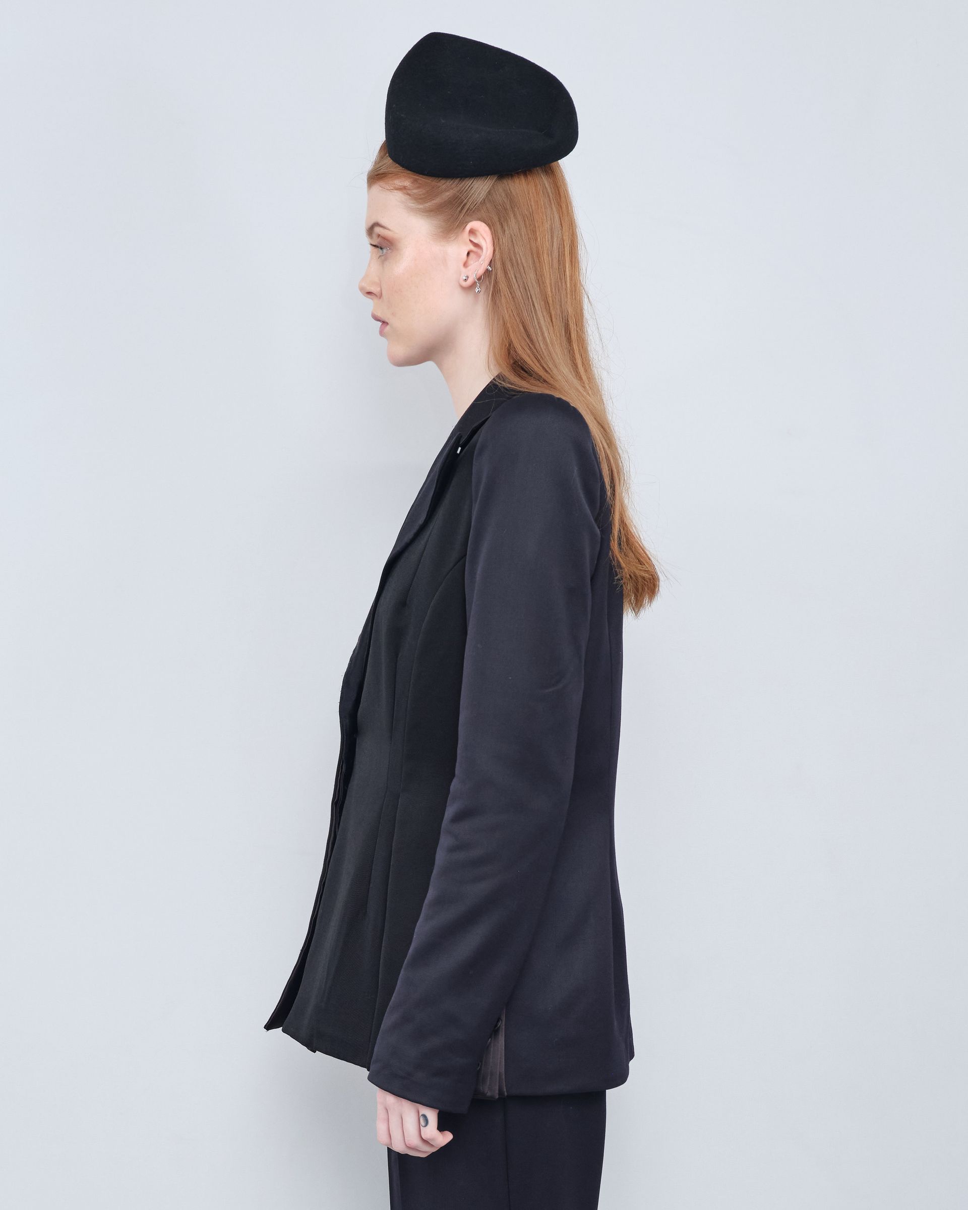 A woman is wearing a black hat and a black jacket.