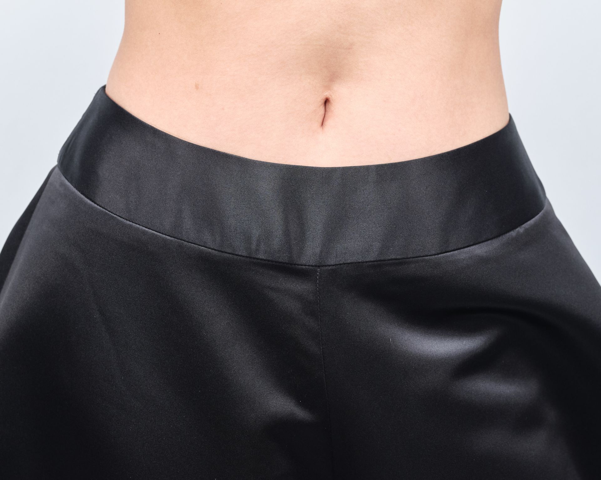 A woman 's stomach is shown in a black skirt