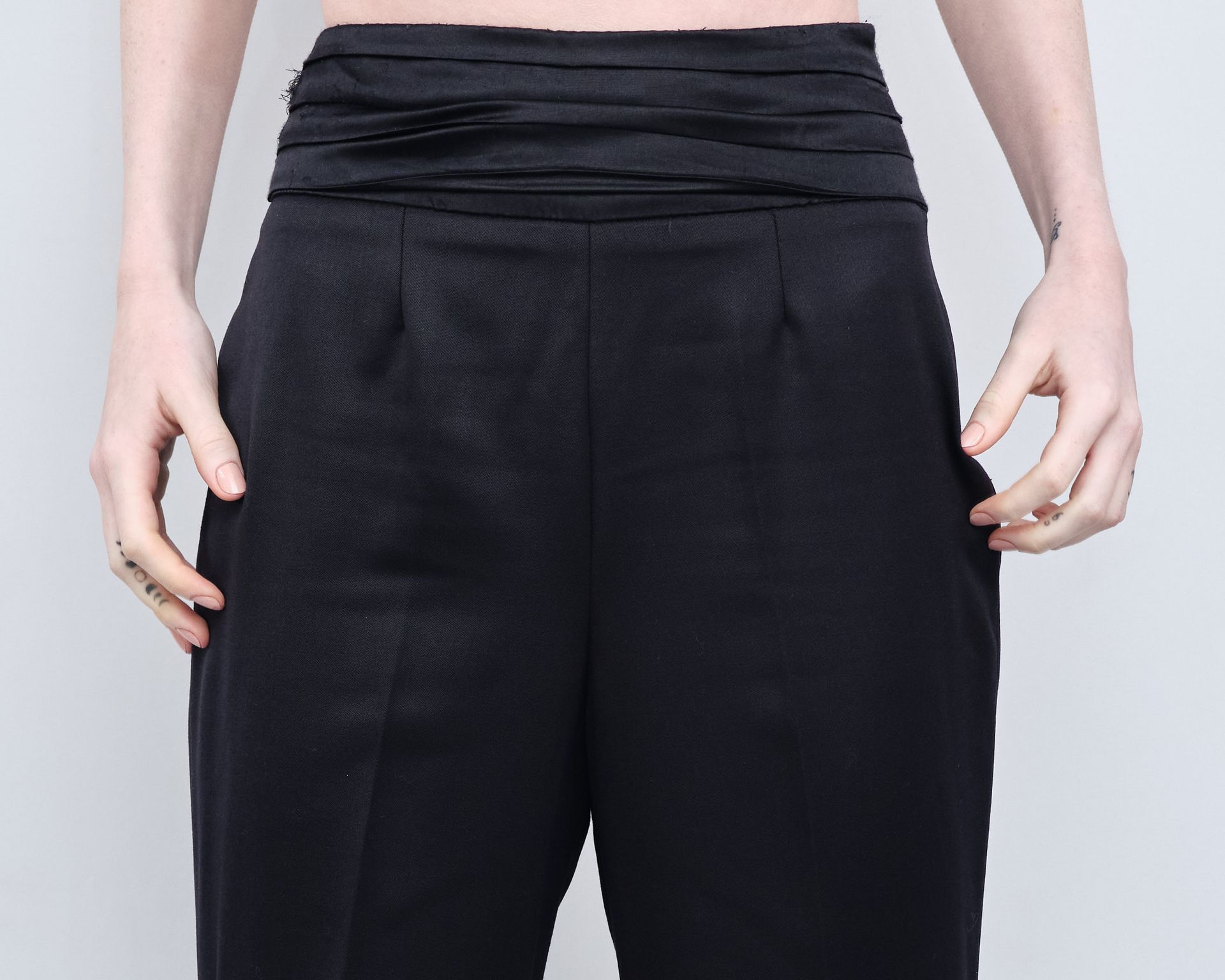 A woman wearing black pants has her hands in her pockets