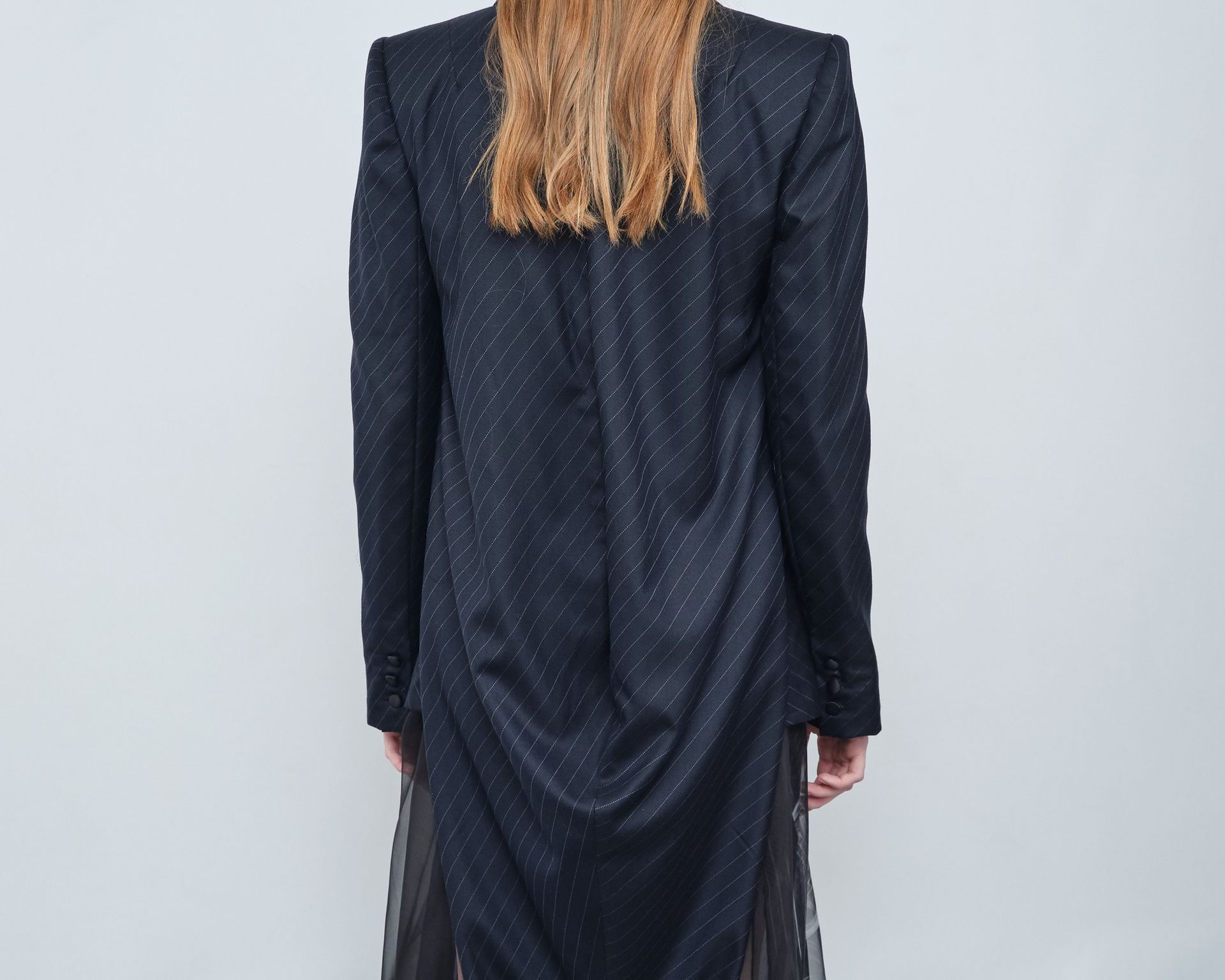 The back of a woman wearing a long black jacket