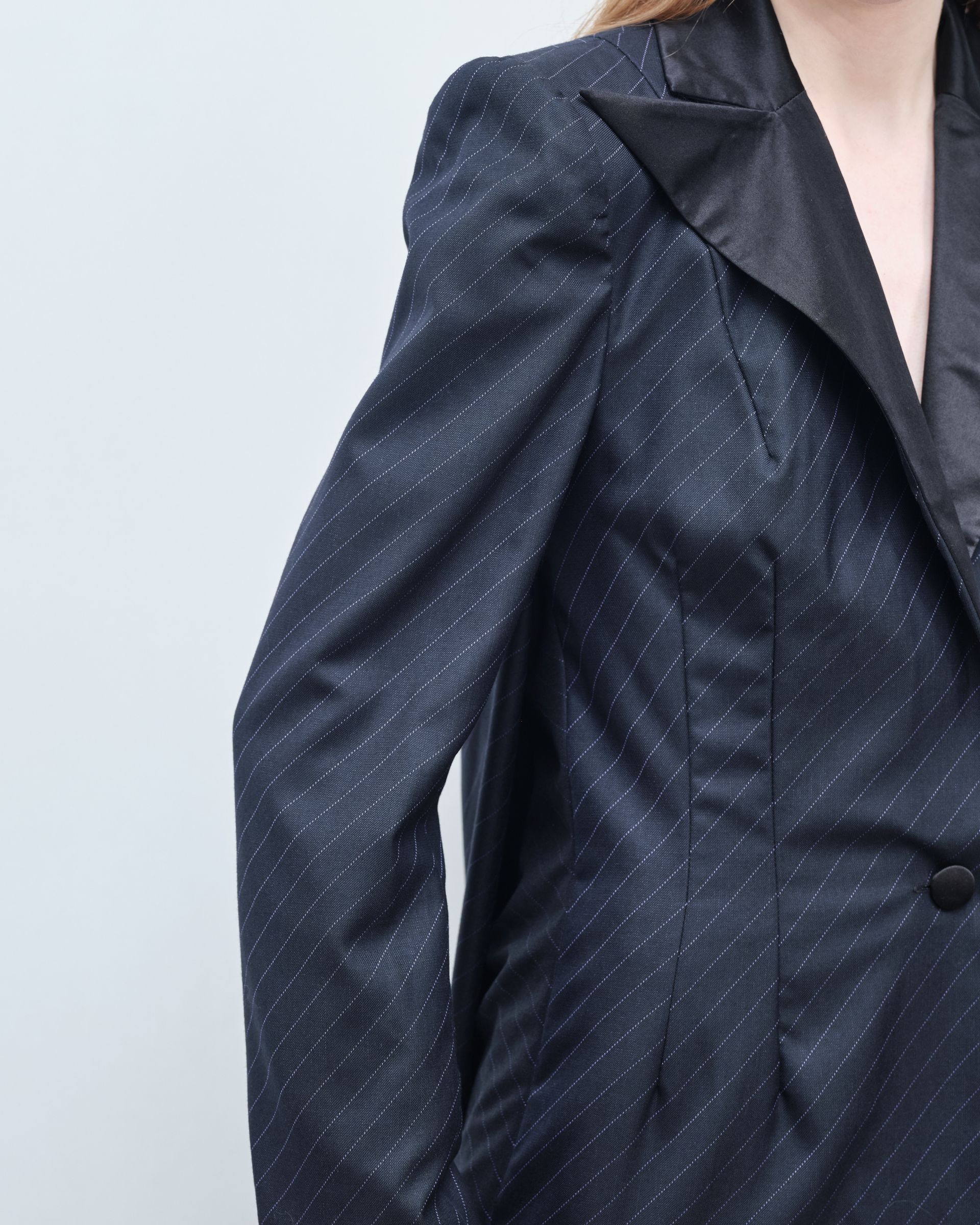 A woman is wearing a black jacket with white polka dots