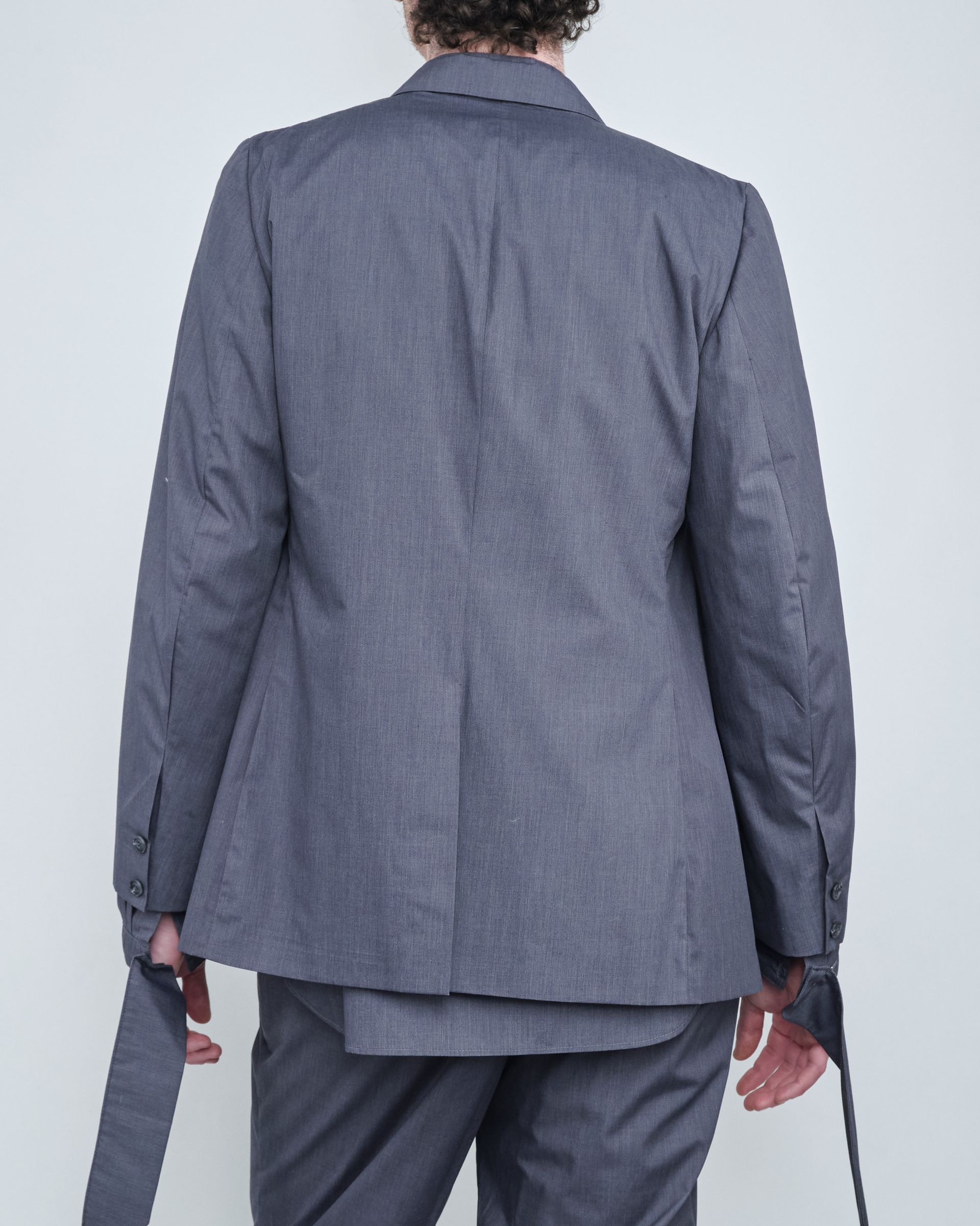 The back of a man wearing a grey suit jacket
