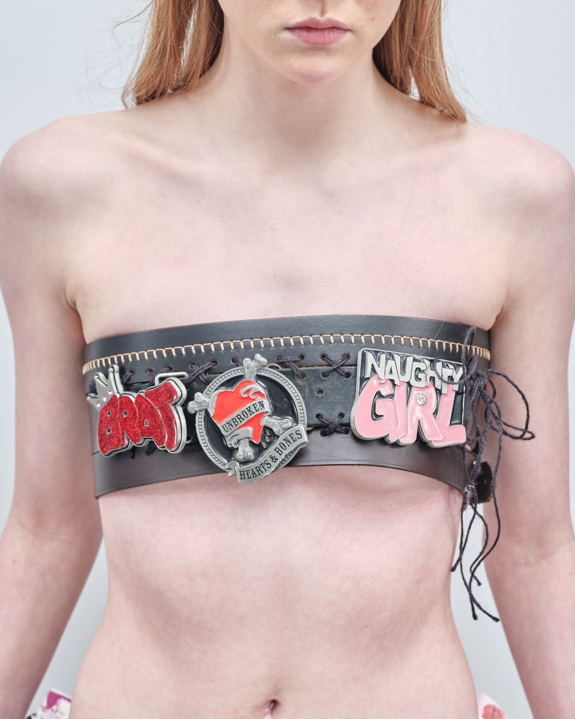 A woman is wearing a strapless top that says nasty girl on it