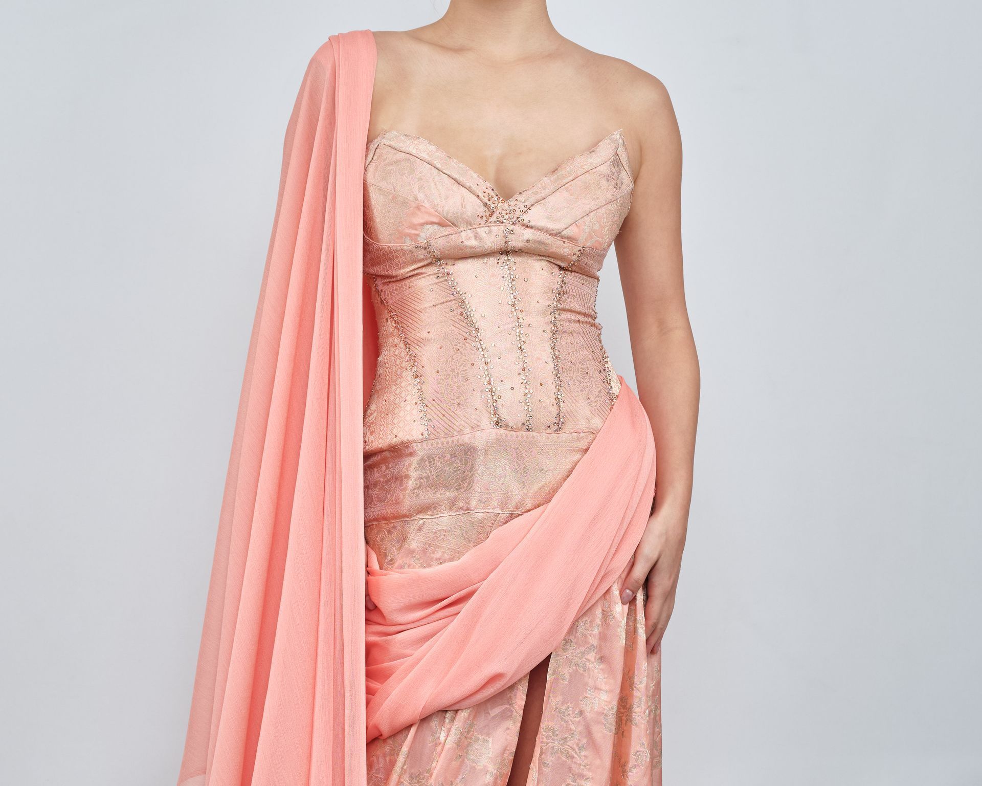 A woman is wearing a strapless dress with a pink shawl.