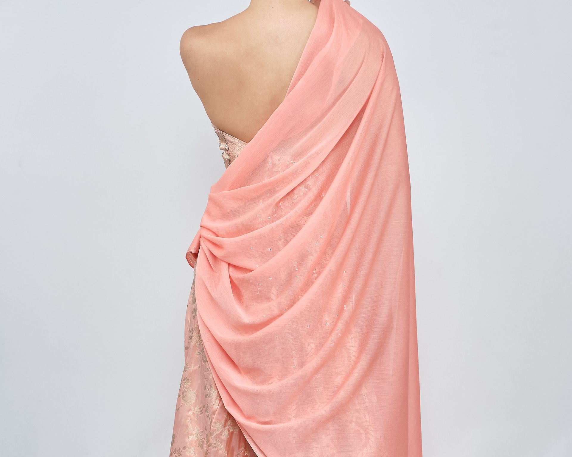 A woman is wearing a strapless dress with a pink shawl.