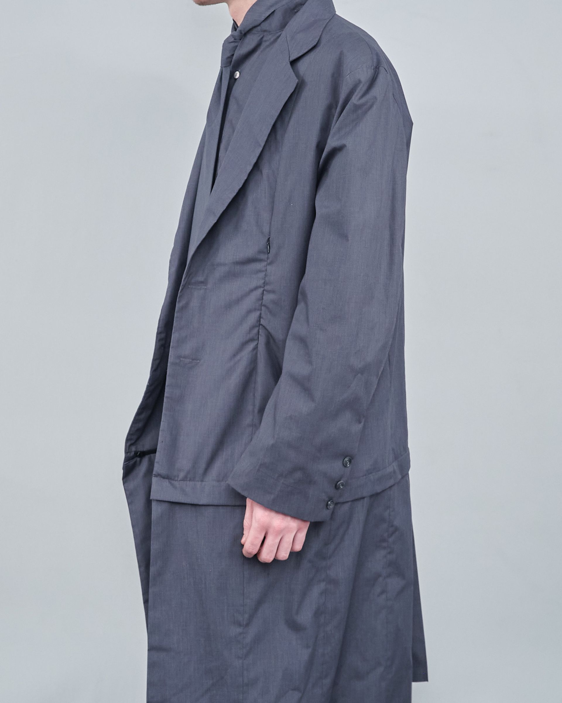 A man is wearing a grey coat and tie