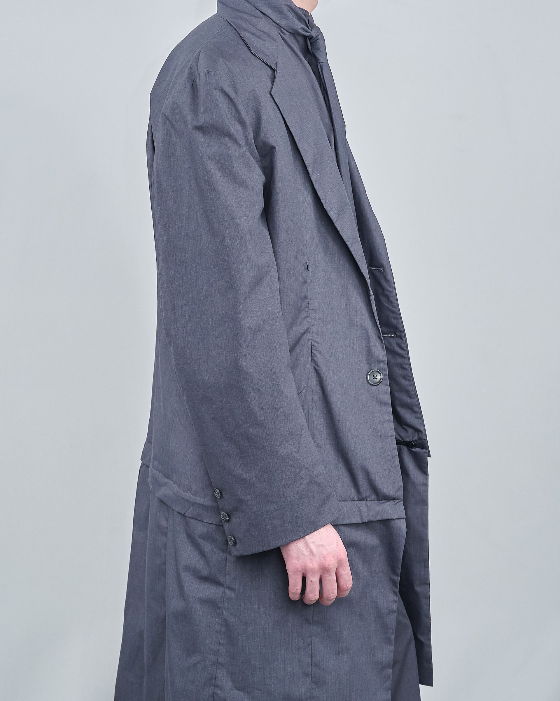 A man is wearing a grey coat and tie