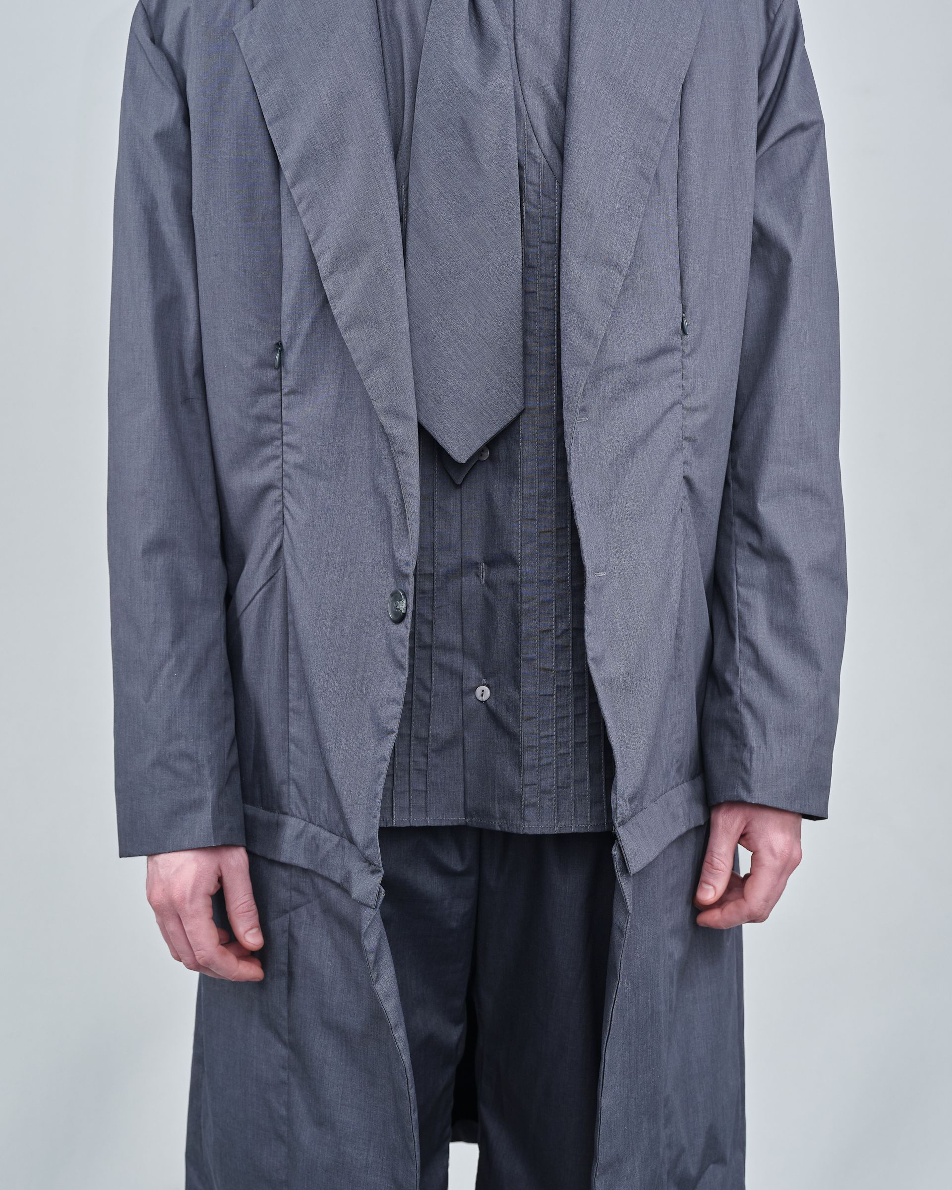 A man is wearing a grey coat and tie