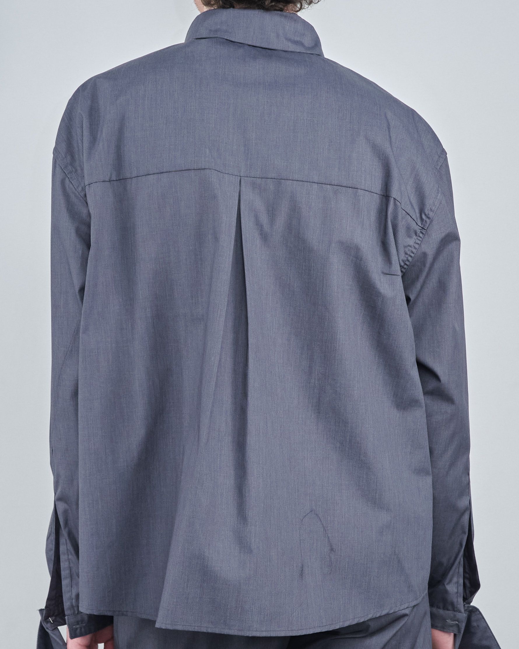 The back of a person wearing a grey shirt