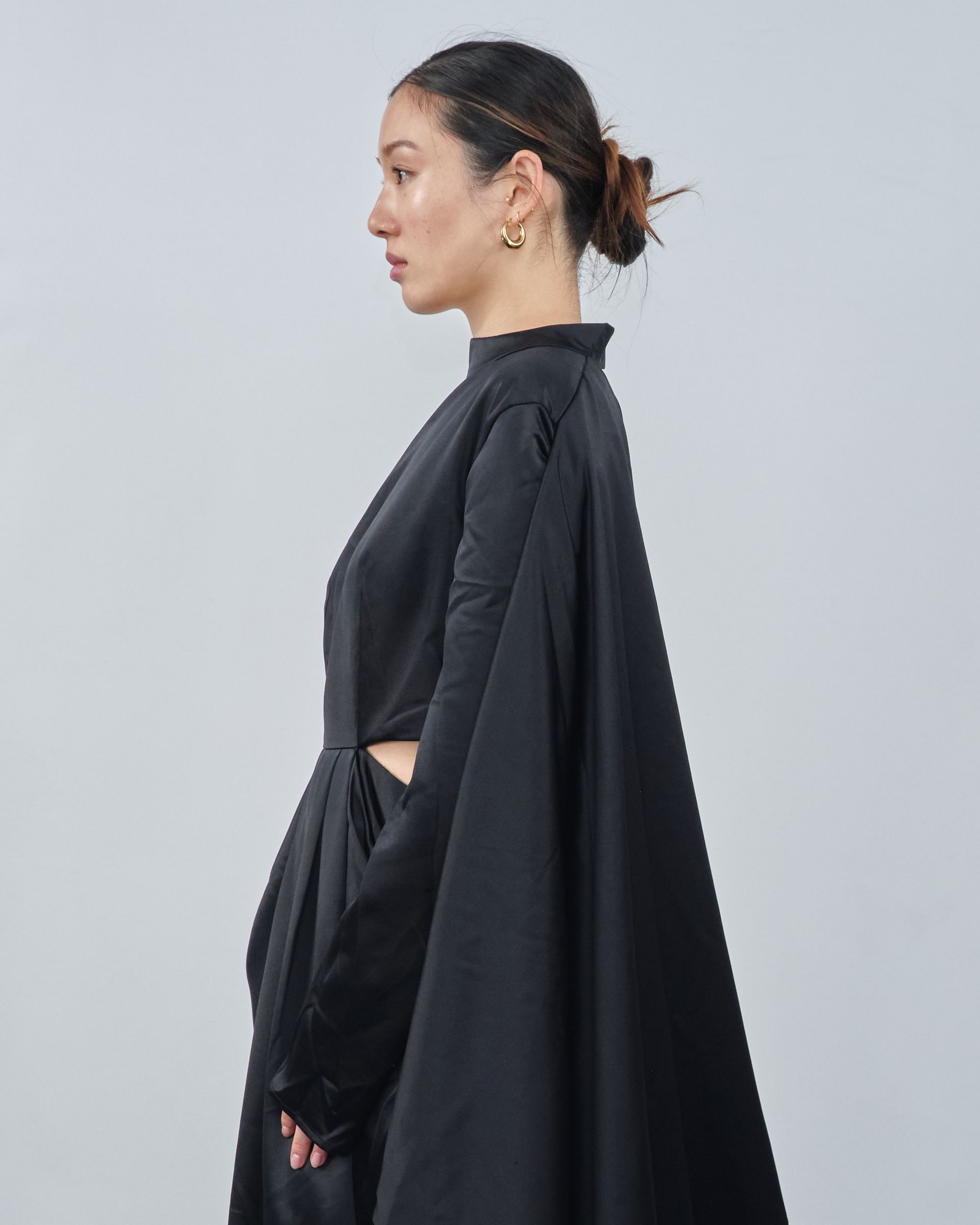 A woman is wearing a black one shoulder dress