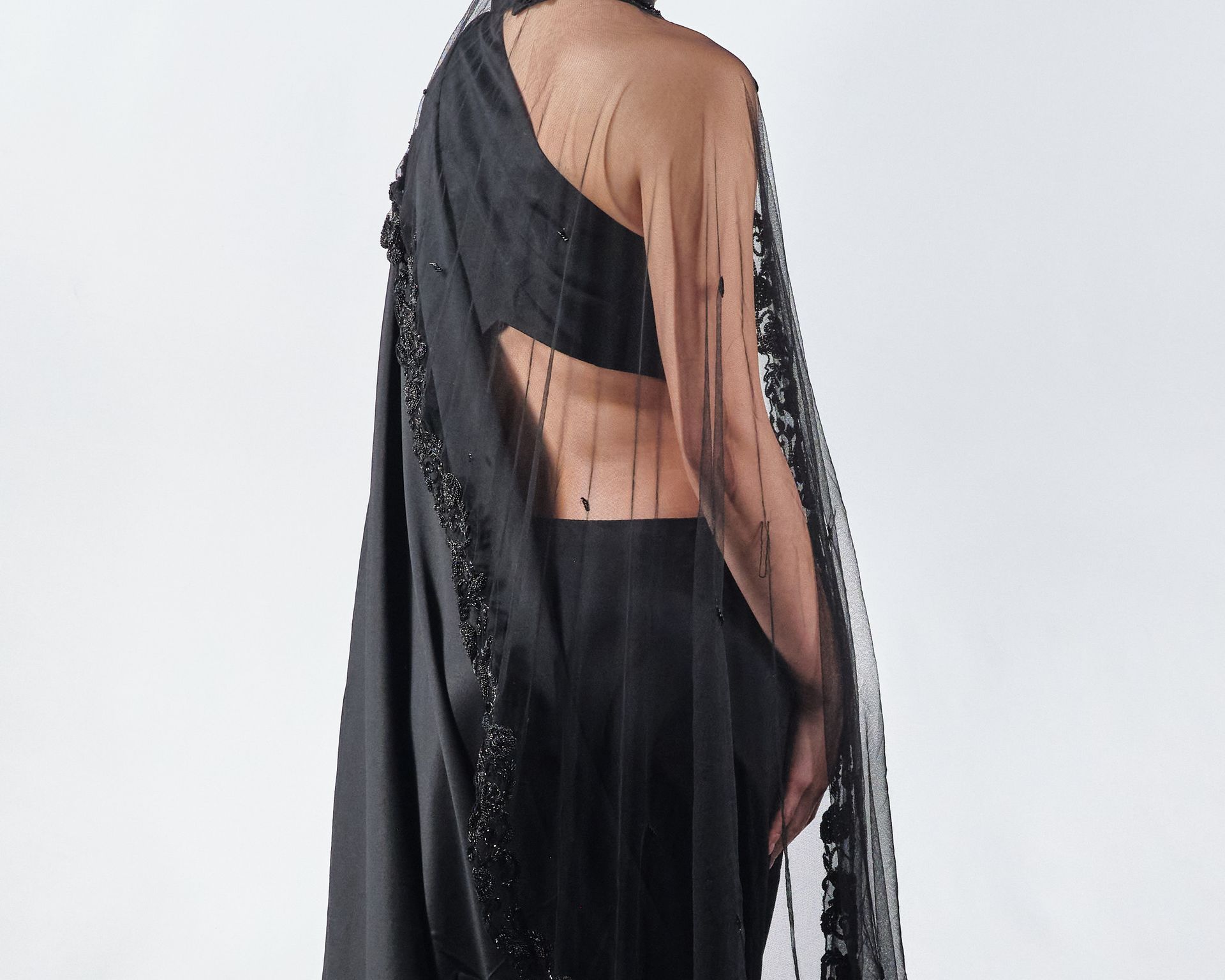 A woman is wearing a black crop top and black pants