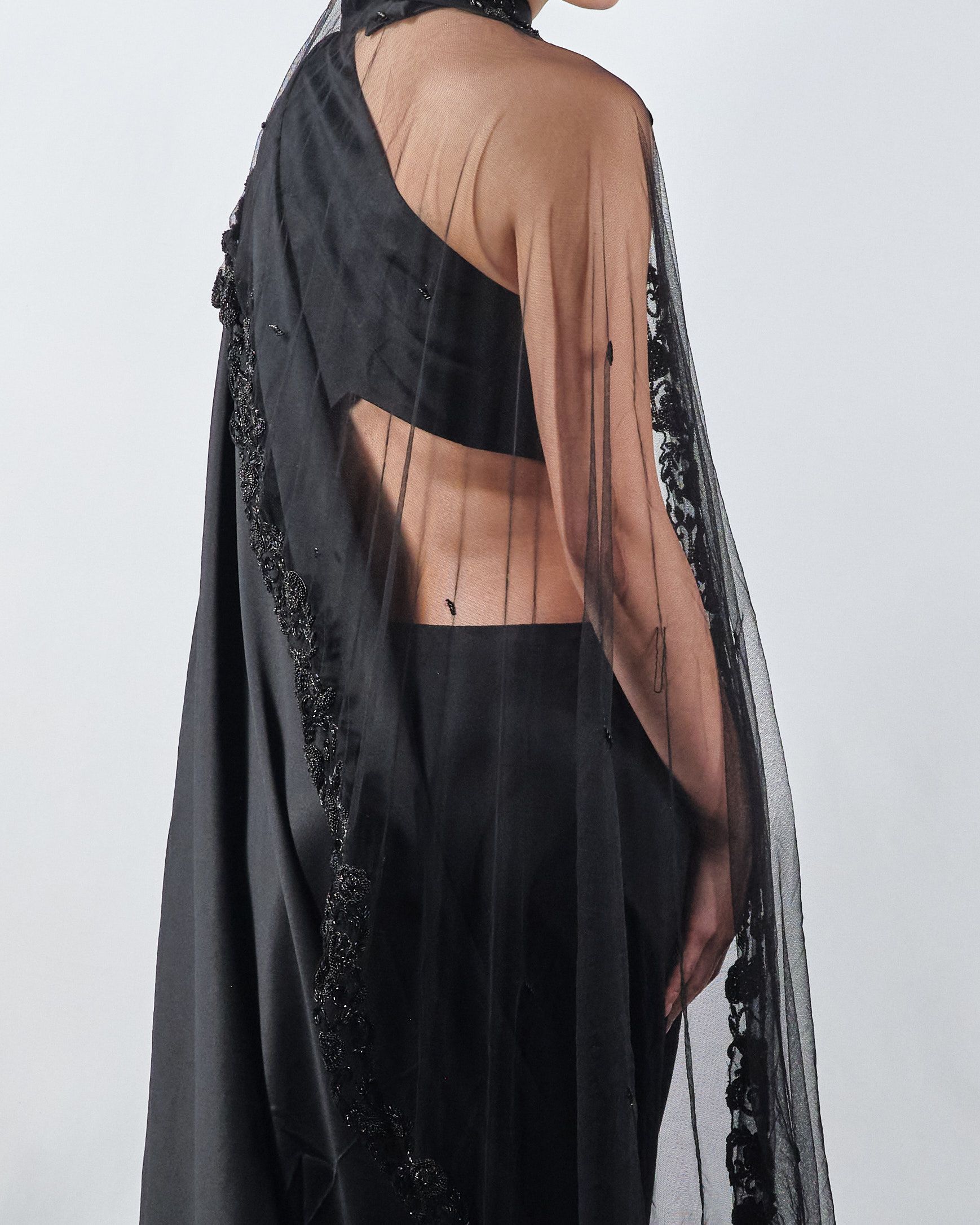 A woman is wearing a black crop top and black pants