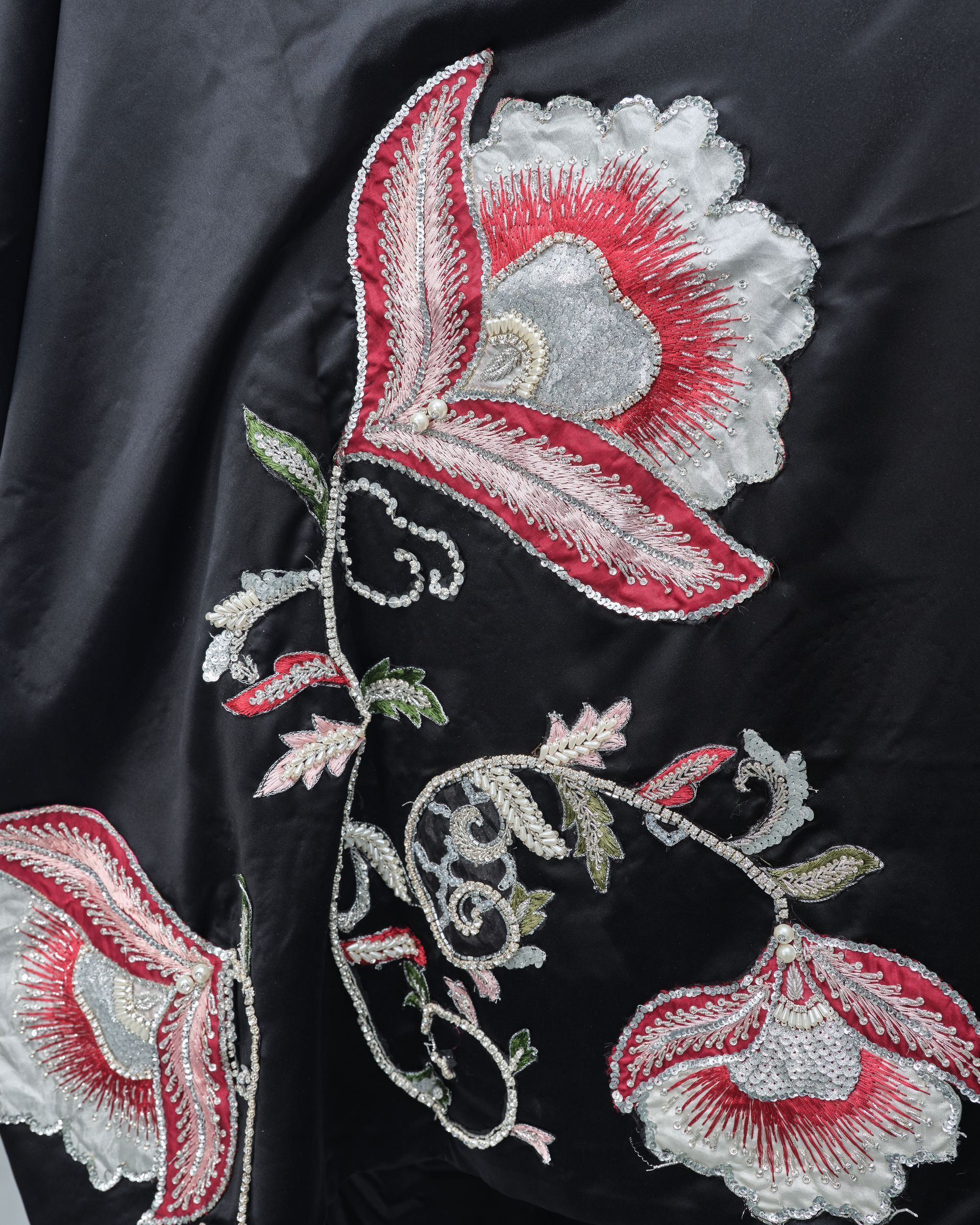 A close up of a floral embroidery on a black cloth