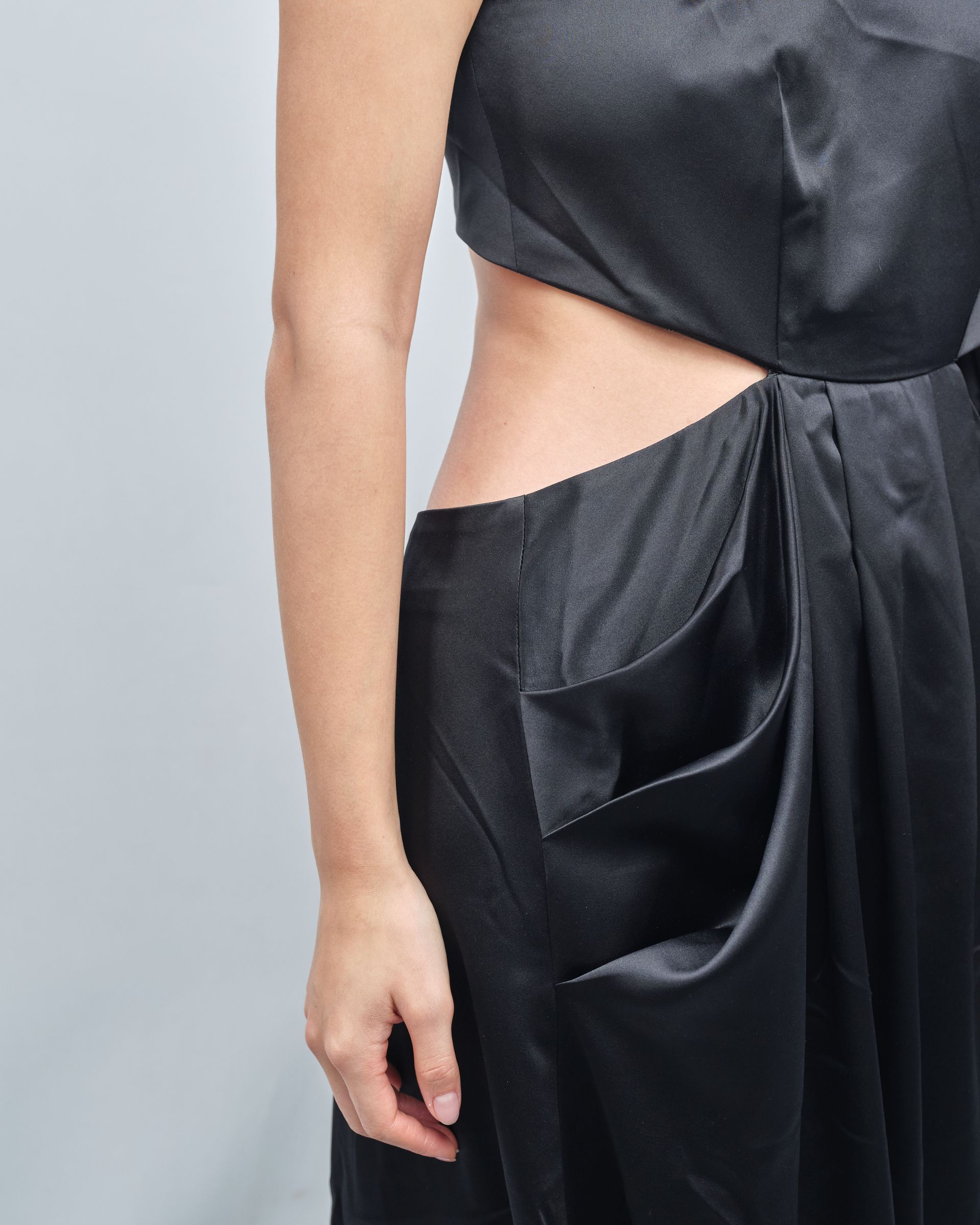 A woman is wearing a black dress with a cut out on the side