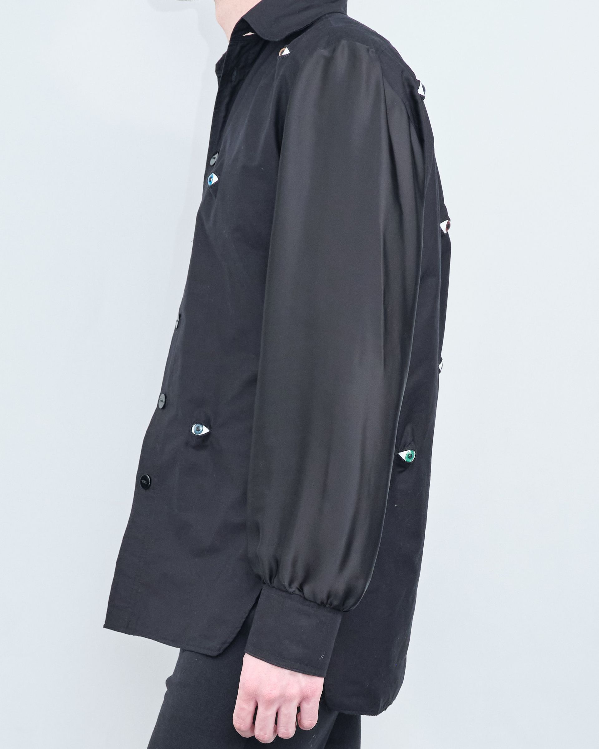 A person wearing a black shirt with puffed sleeves