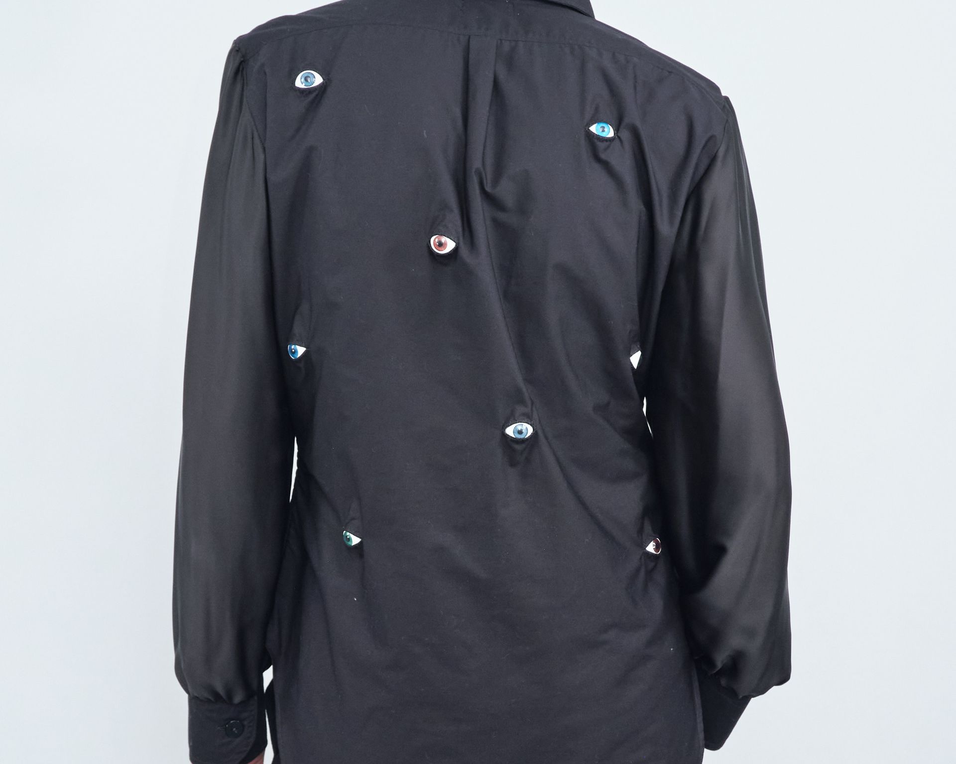 The back of a black shirt with buttons on it