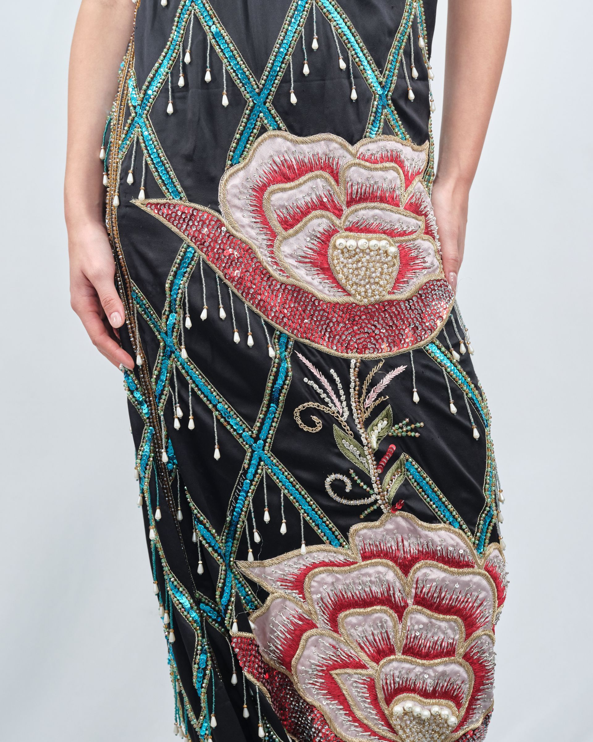 A woman is wearing a black dress with flowers on it