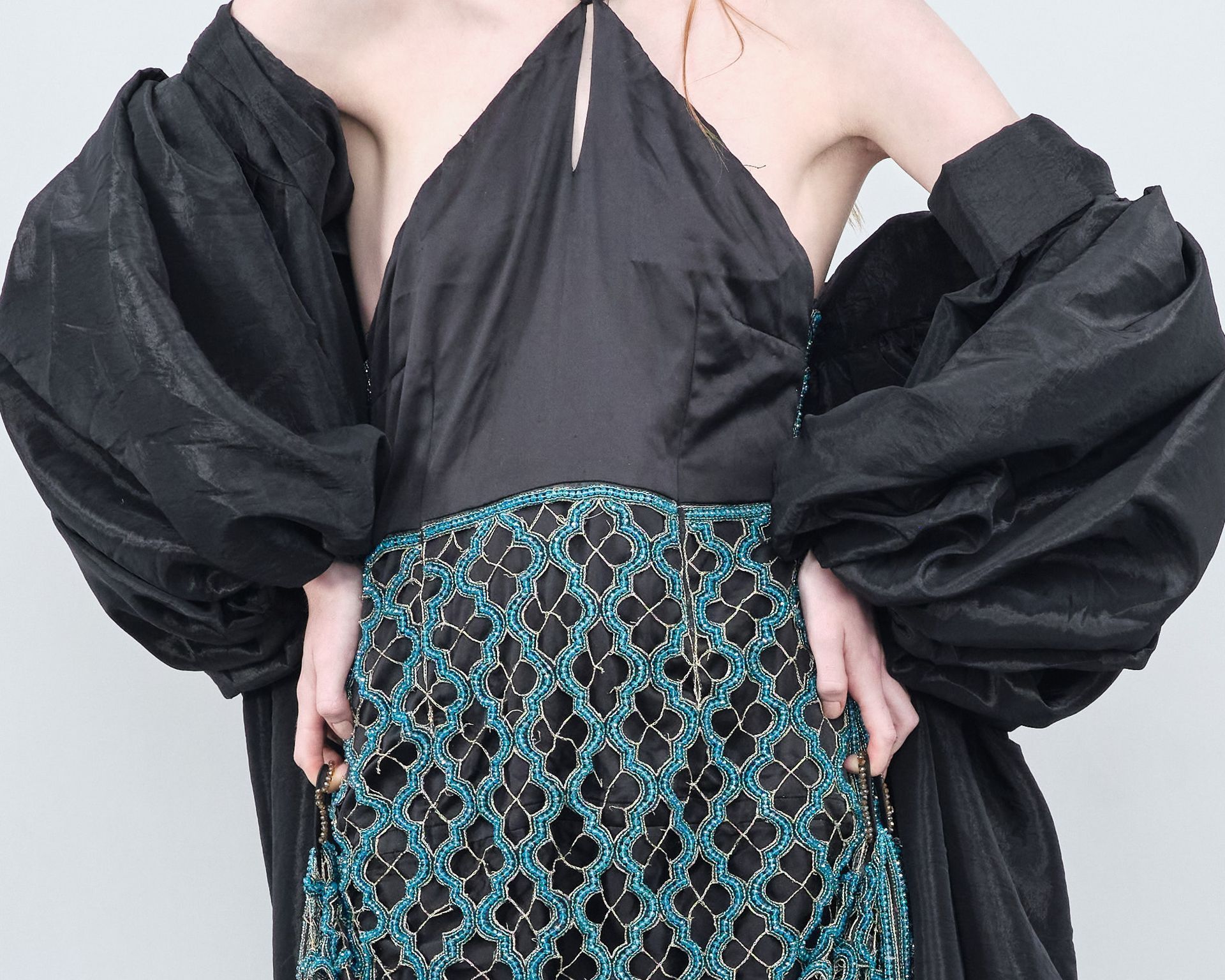 A woman wearing a black dress with puffed sleeves