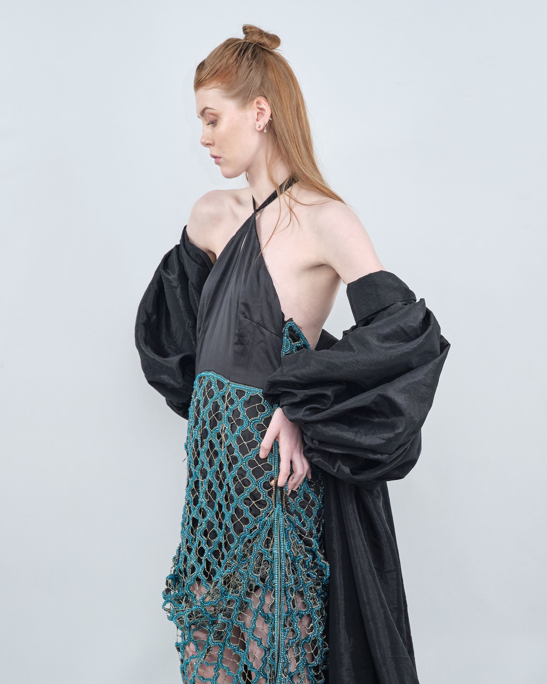 A woman is wearing a black top and a blue skirt.