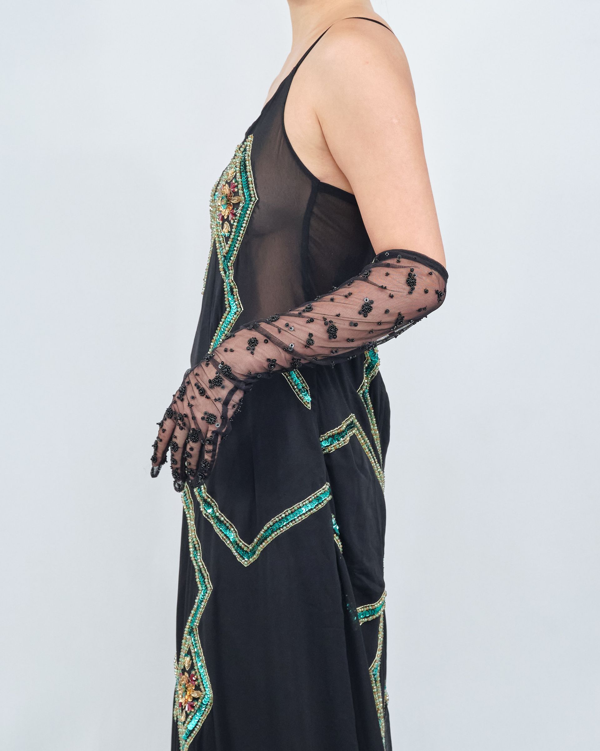 A woman wearing a black dress and long black gloves