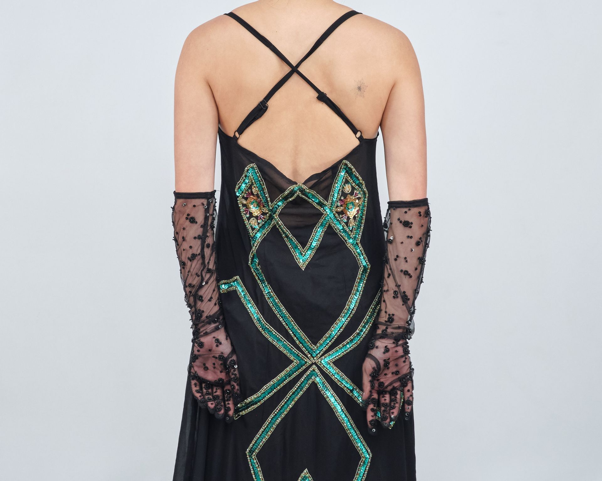 The back of a woman wearing a black dress and gloves