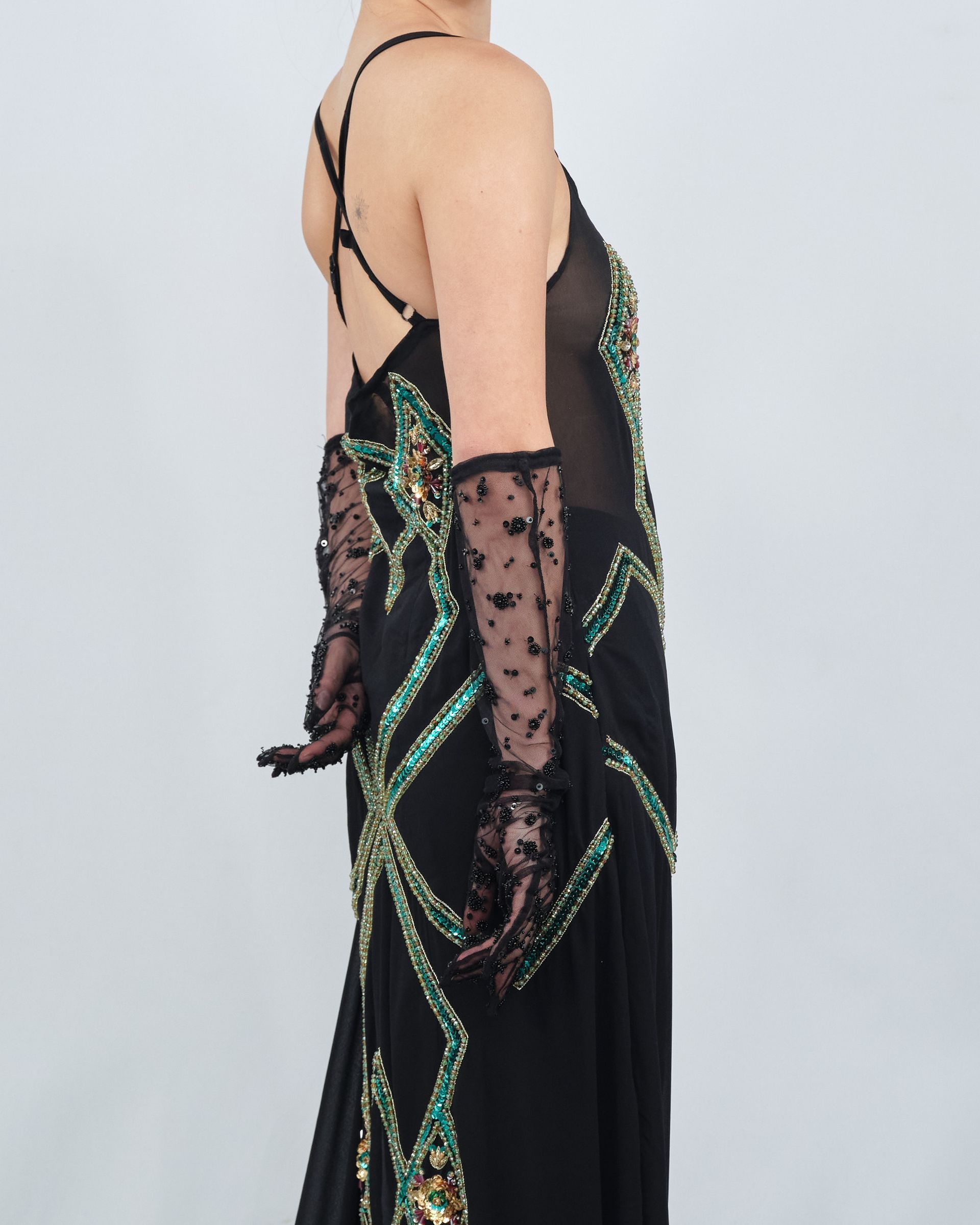 A woman wearing a black dress and long gloves