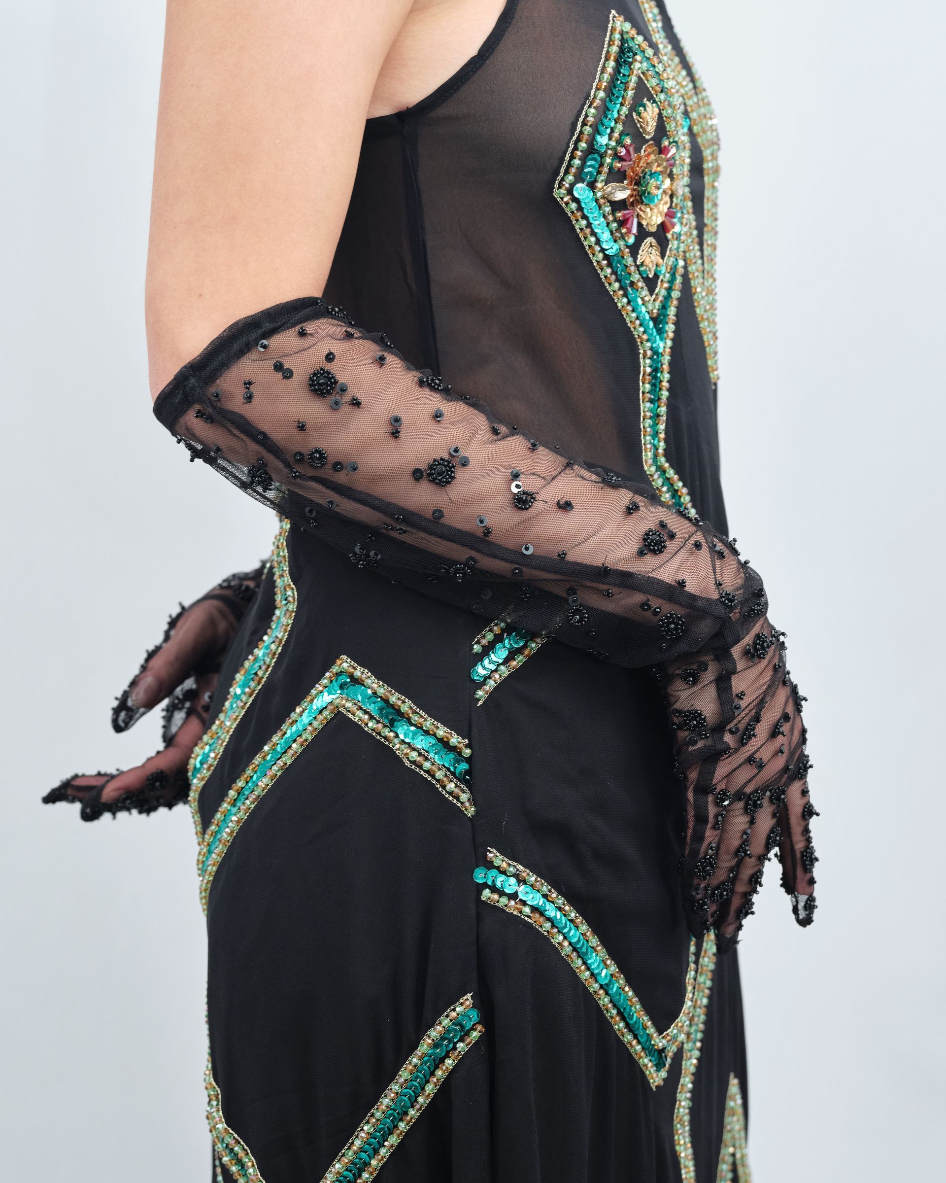 A woman wearing a black dress and long gloves