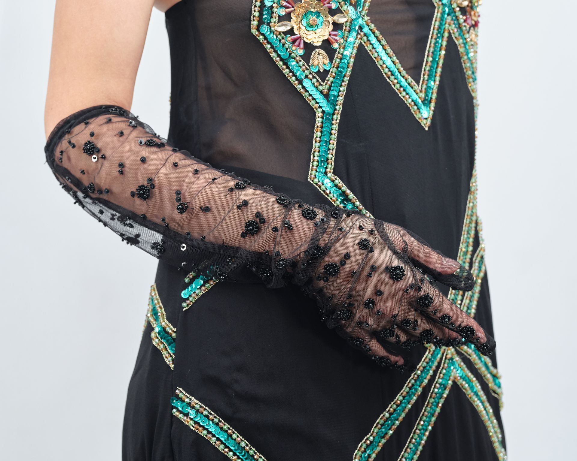 A woman wearing a black dress and long gloves