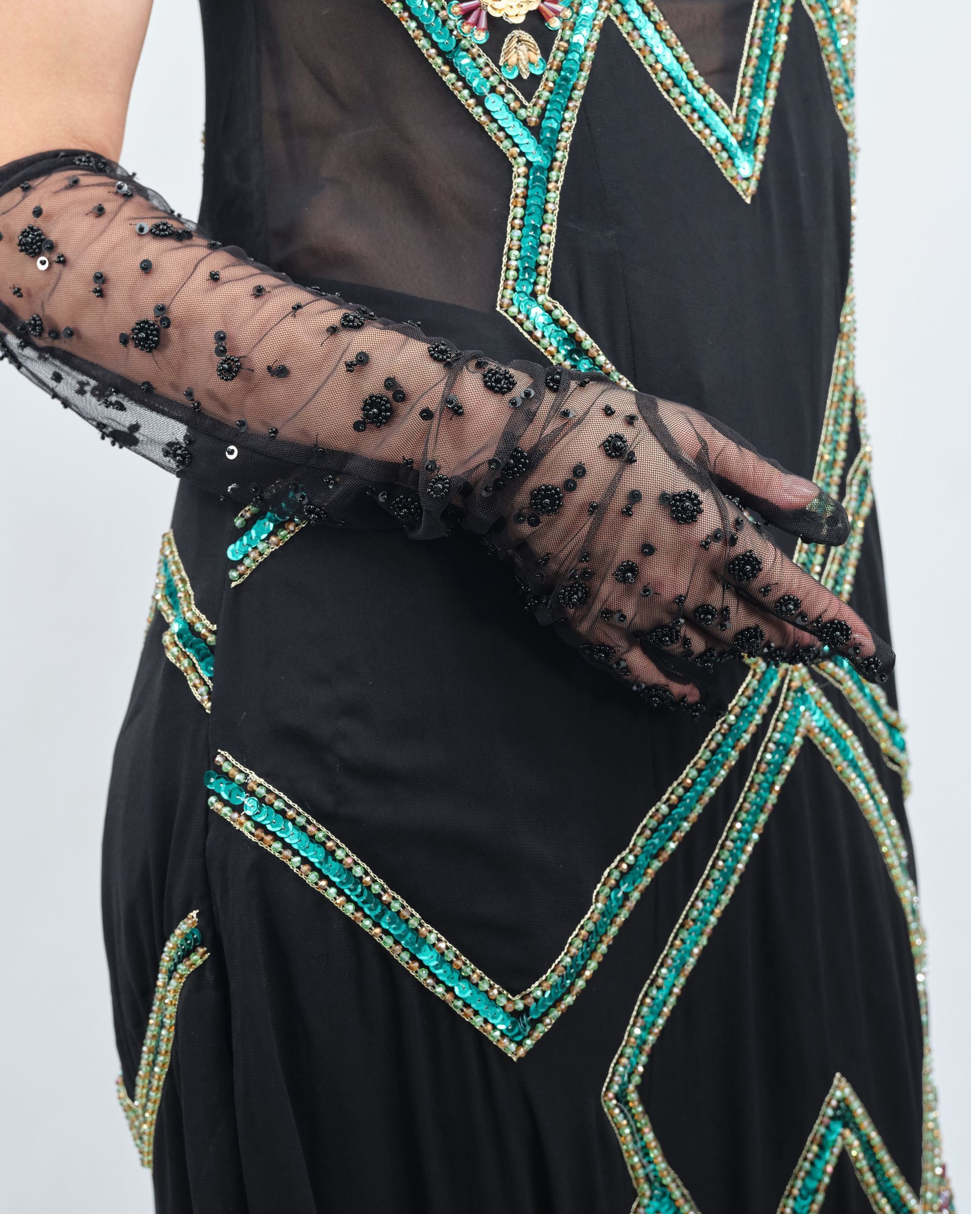 A woman wearing a black dress and long black gloves