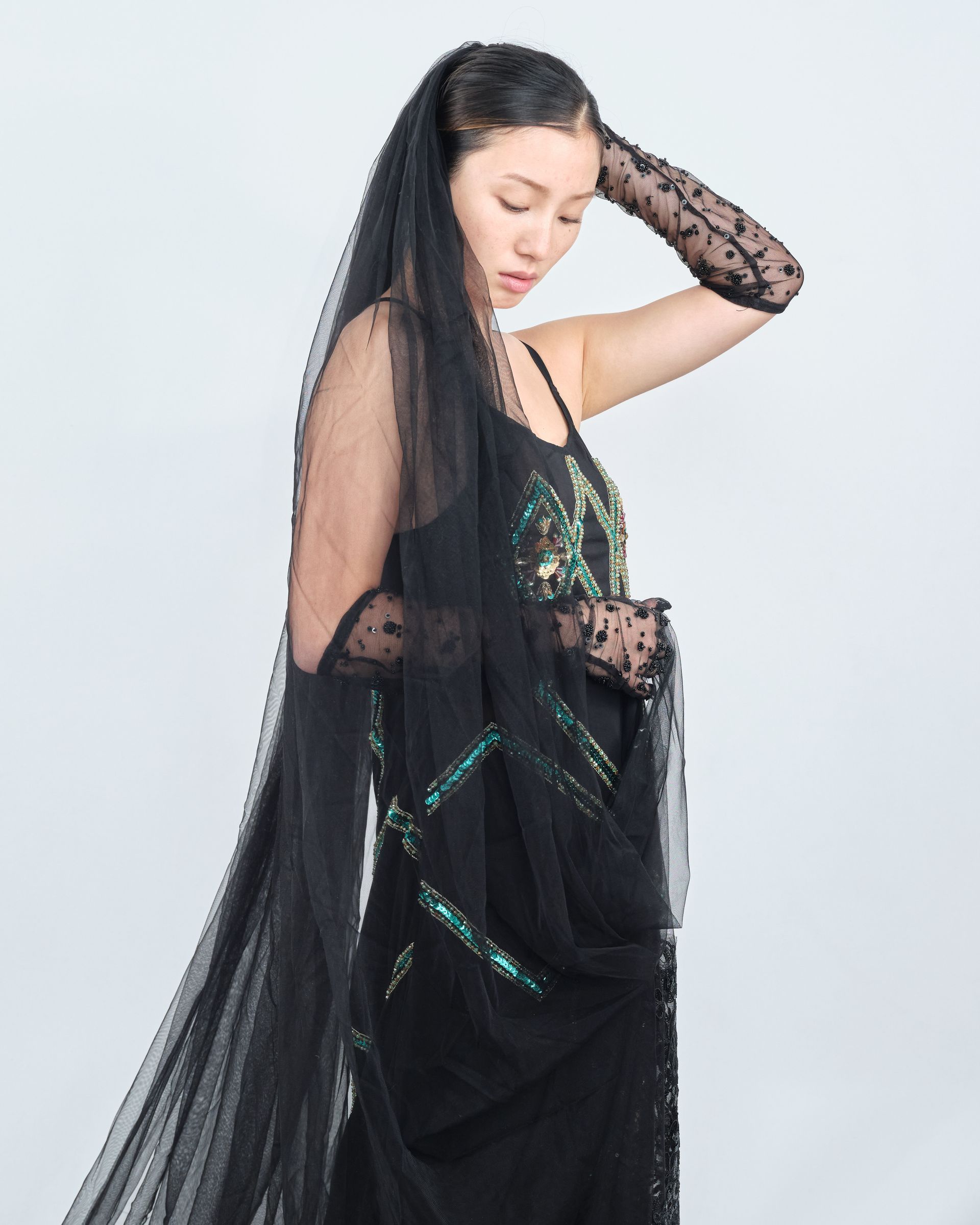 A woman wearing a long black veil and gloves
