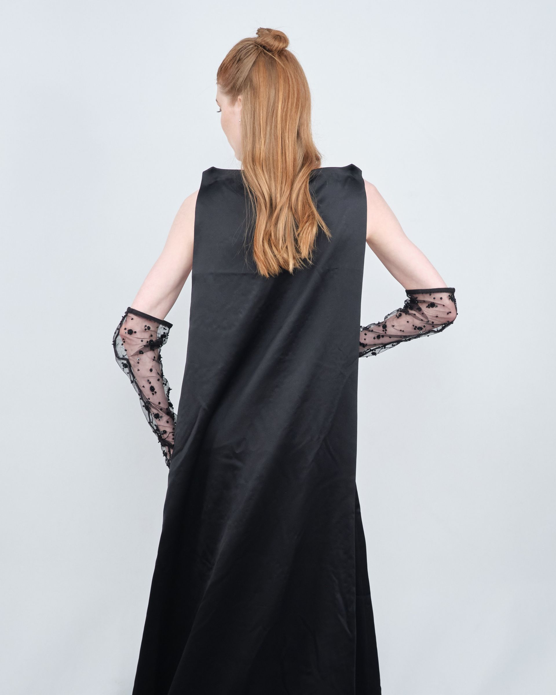 A woman wearing a black dress and long lace gloves