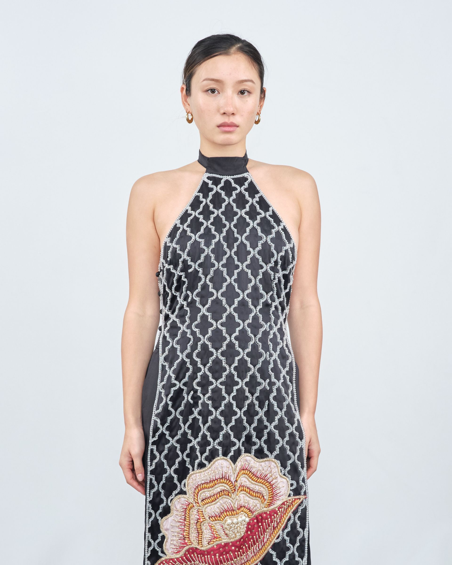 A woman is wearing a black and white dress with a halter neckline.