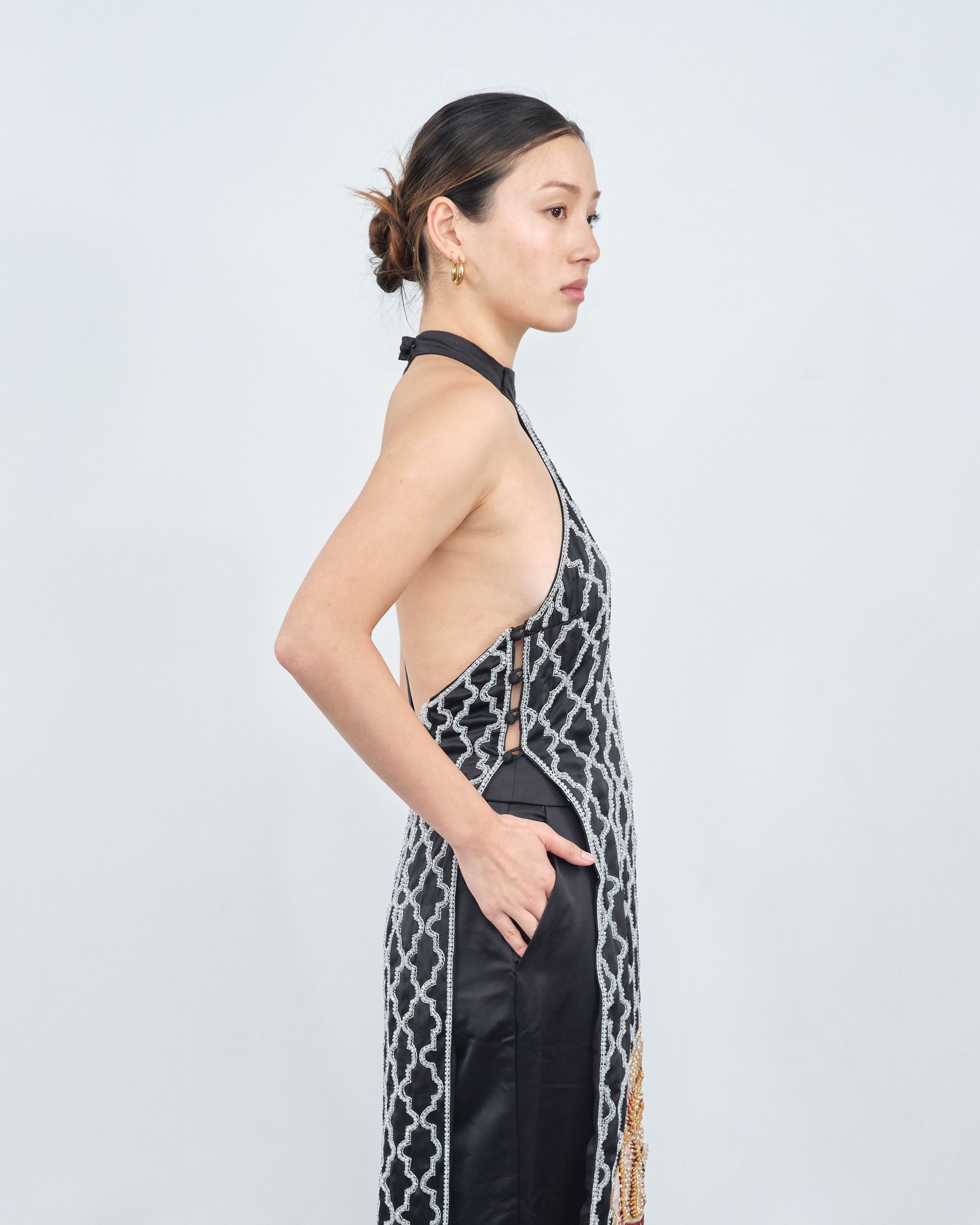 A woman is wearing a black and white dress with a halter neckline.