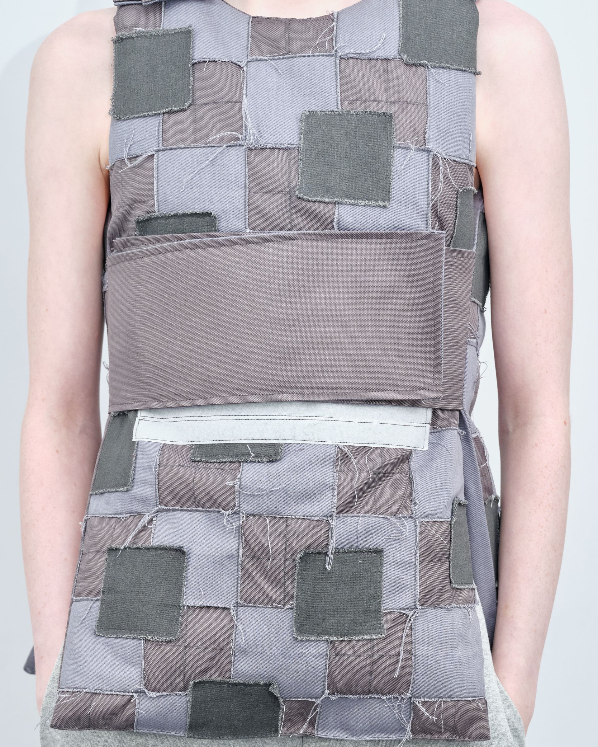 A woman is wearing a gray and black patchwork dress