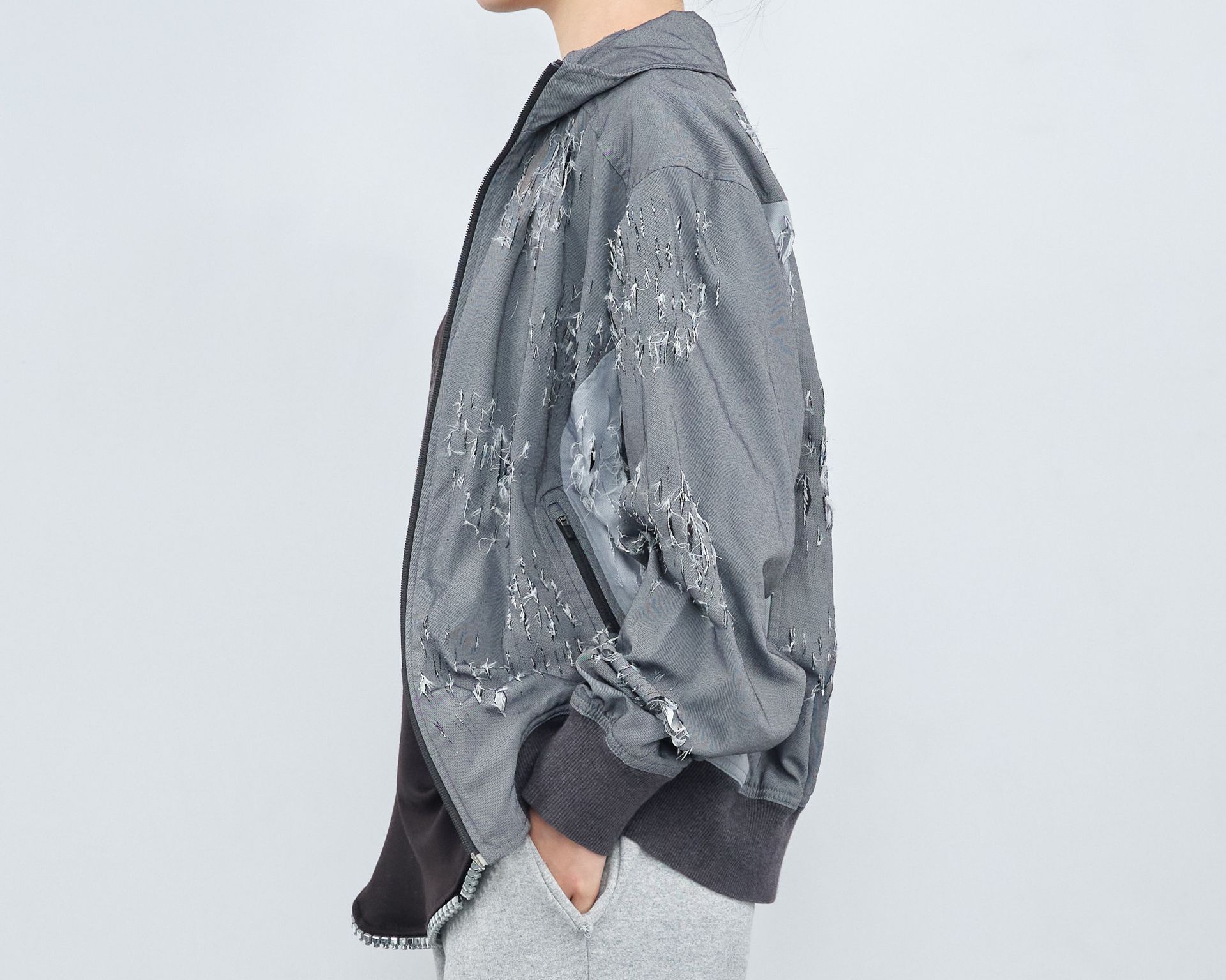 A person is wearing a gray jacket with sequins on the sleeves.