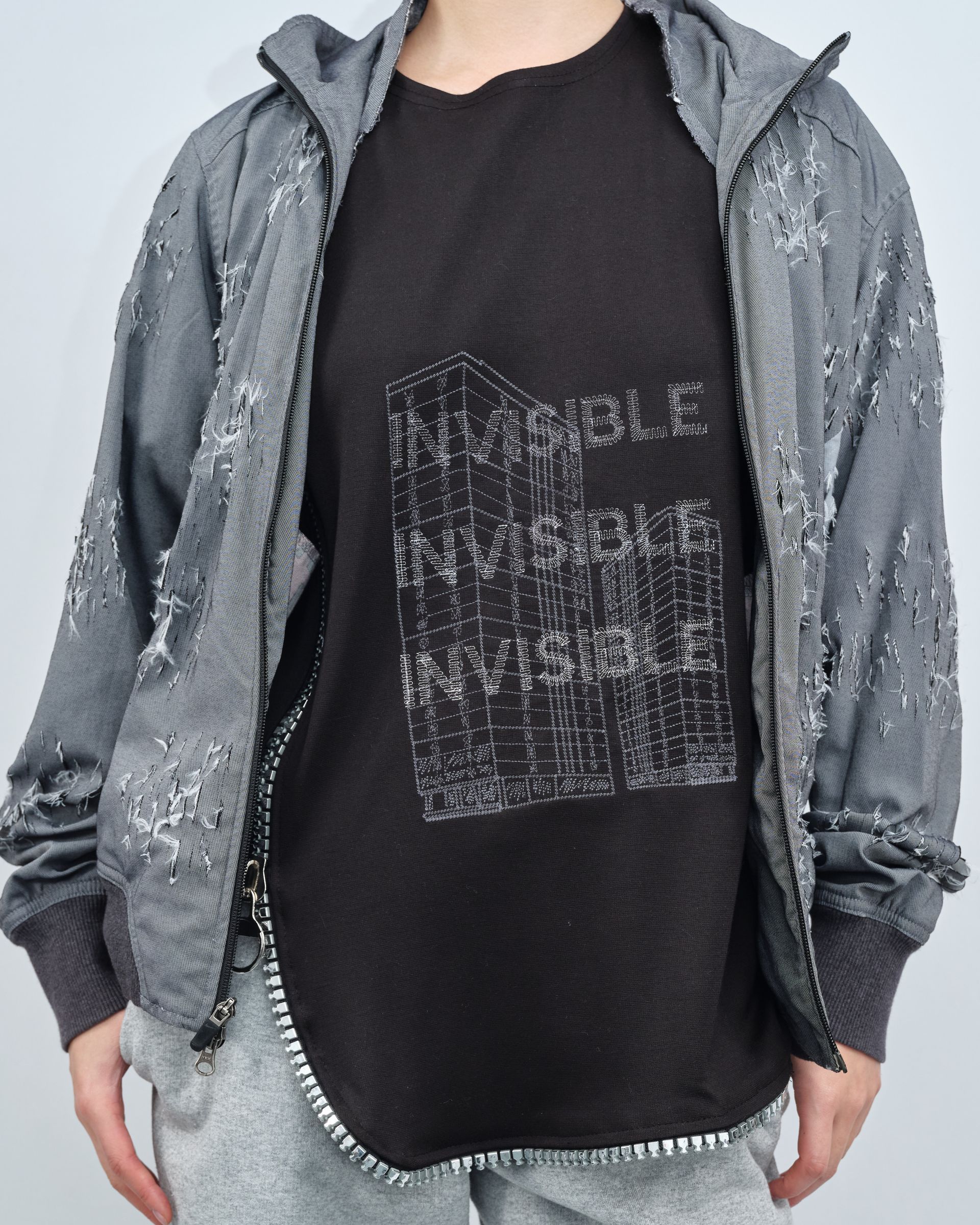 A person wearing a black shirt that says invisible