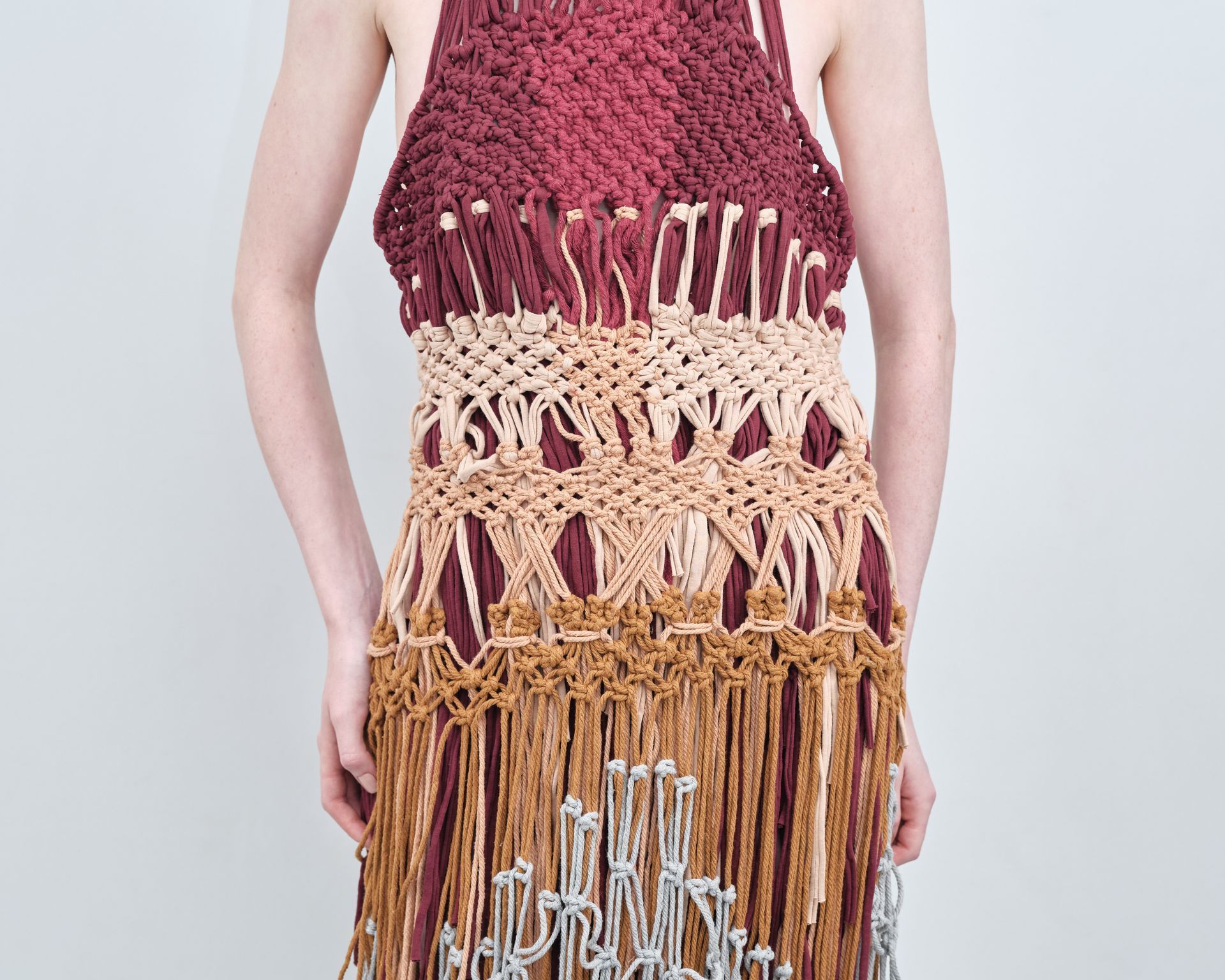 A woman is wearing a knitted dress with fringe.
