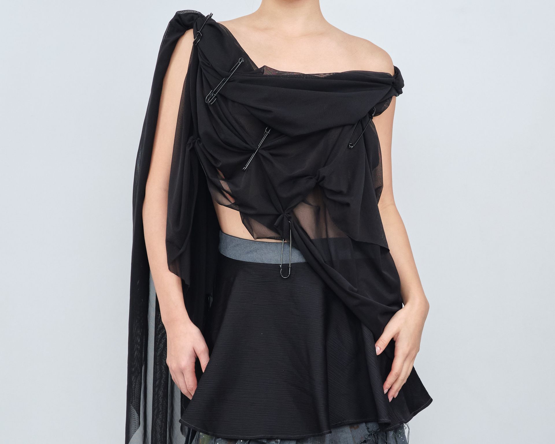 A woman is wearing a black top and a black skirt