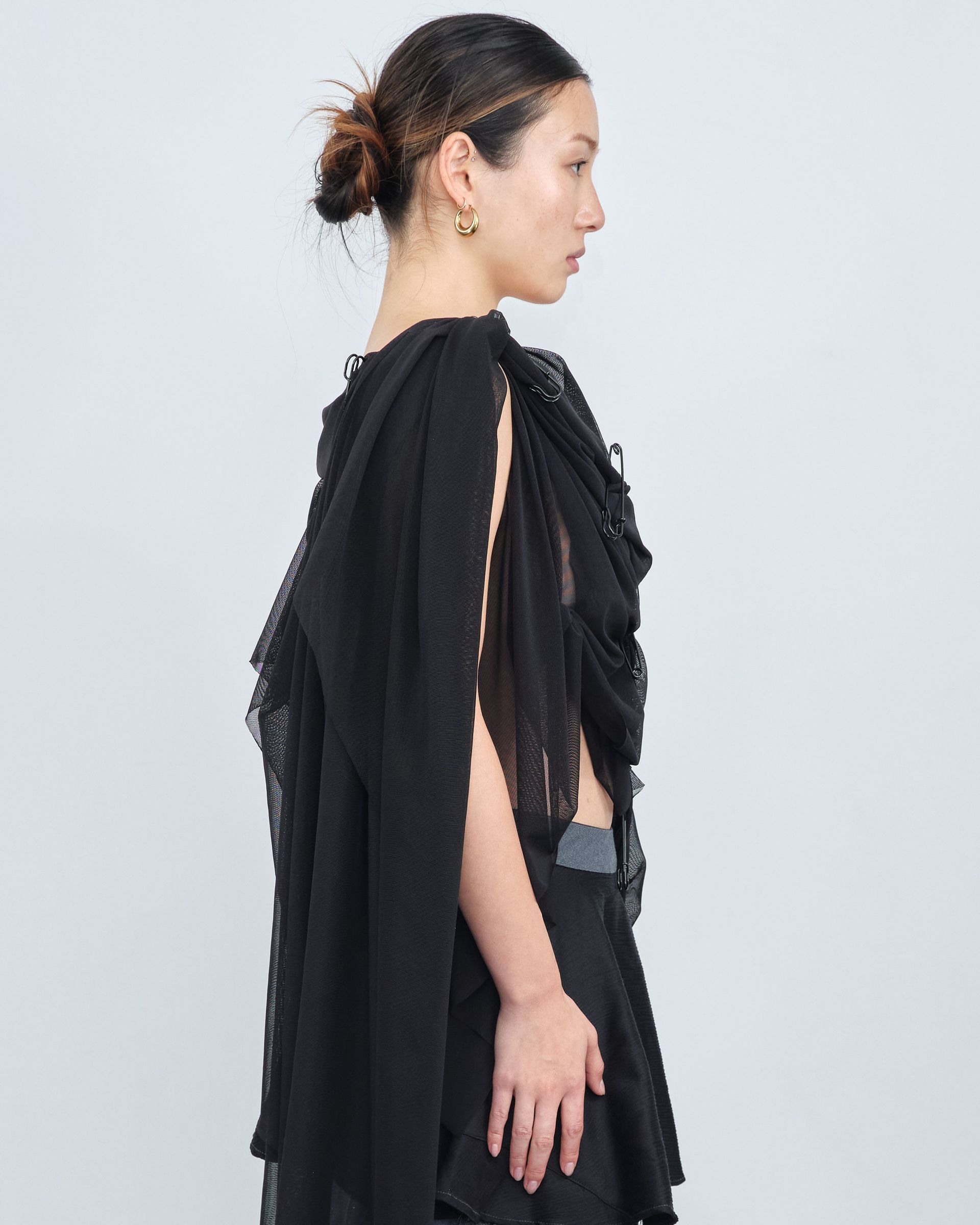 A woman is wearing a black top and a black skirt