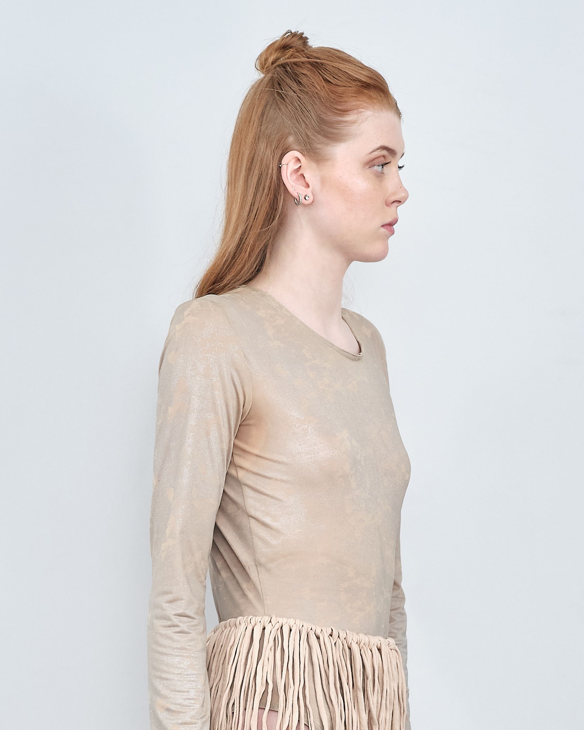 A woman is wearing a gold top and a leopard print skirt.