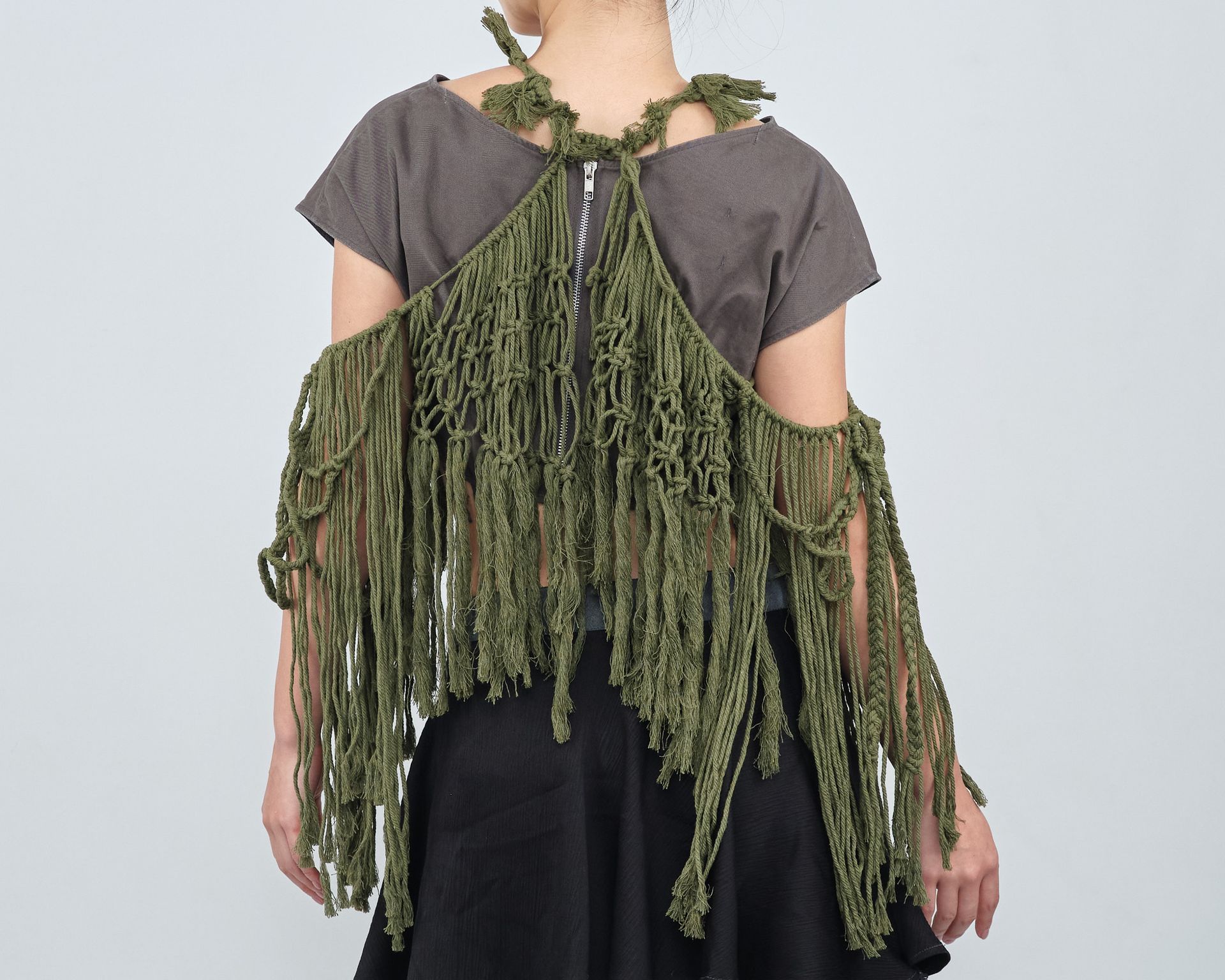 The back of a woman wearing a green fringed top