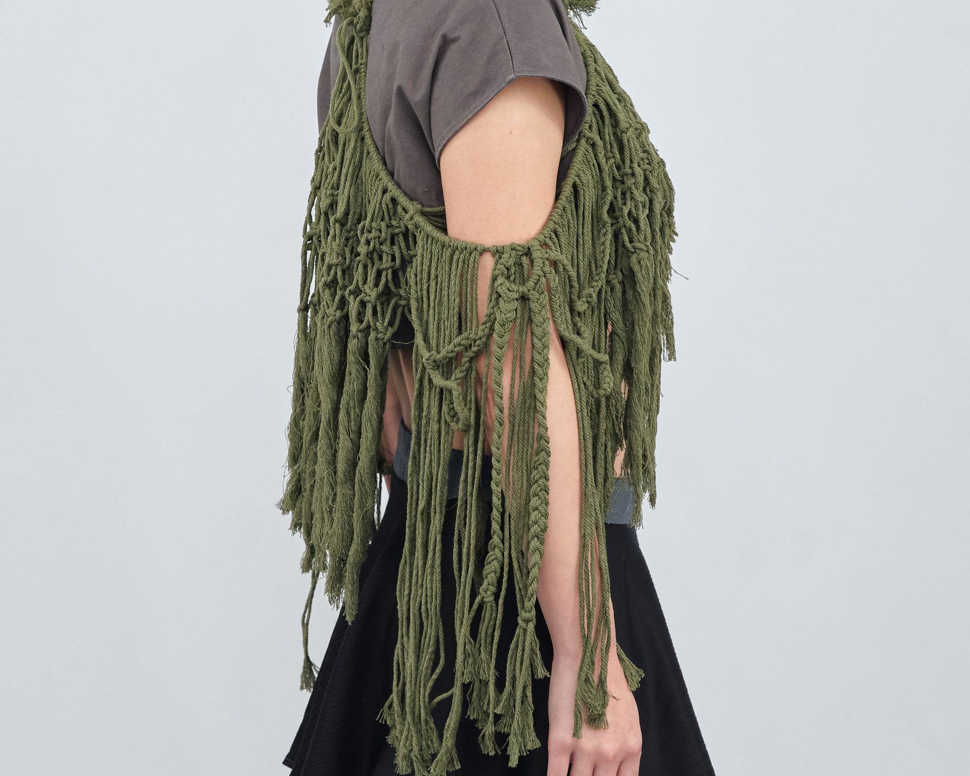 The back of a woman wearing a green fringed top