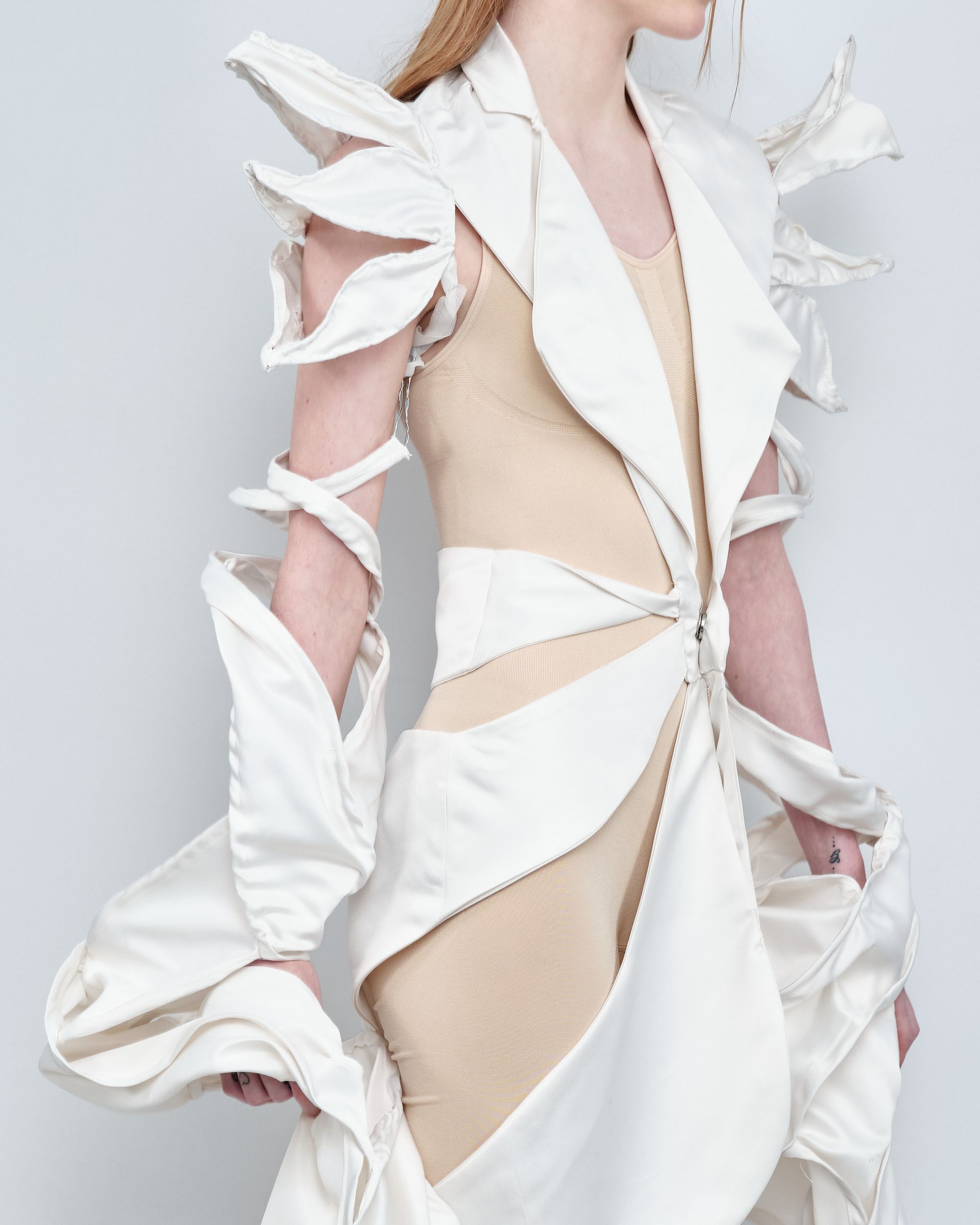 A woman is wearing a white and tan dress