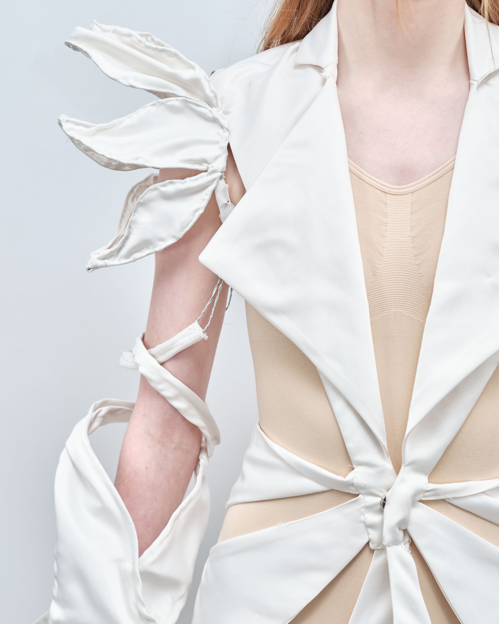 A close up of a woman wearing a white jacket and gloves