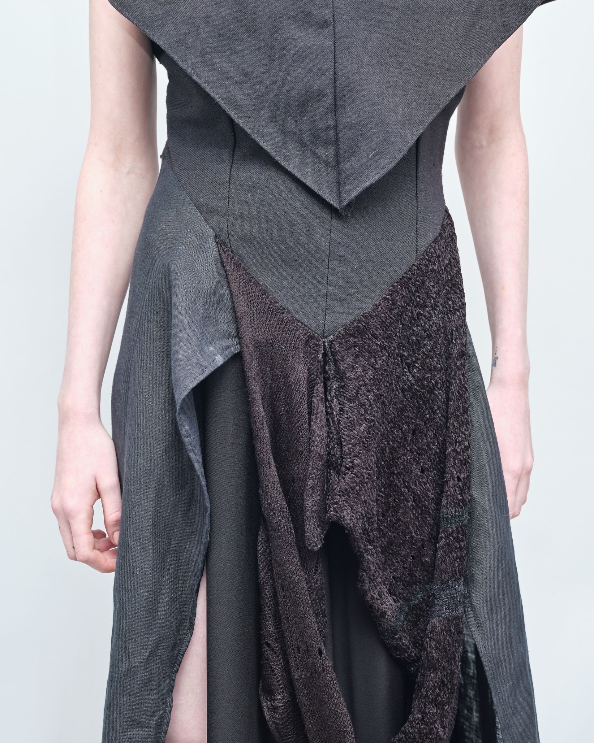 A woman is wearing a gray and brown dress