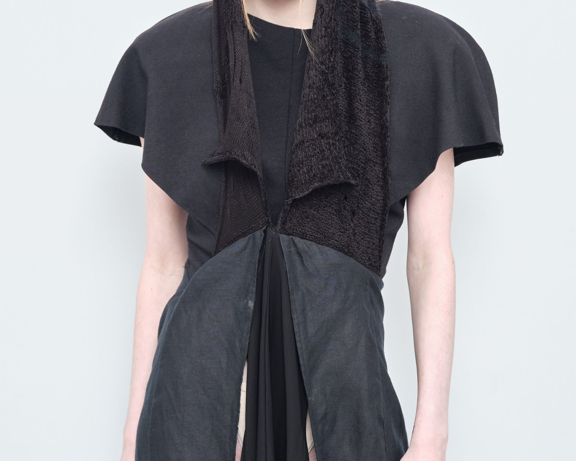 A woman in a black dress with a scarf around her neck