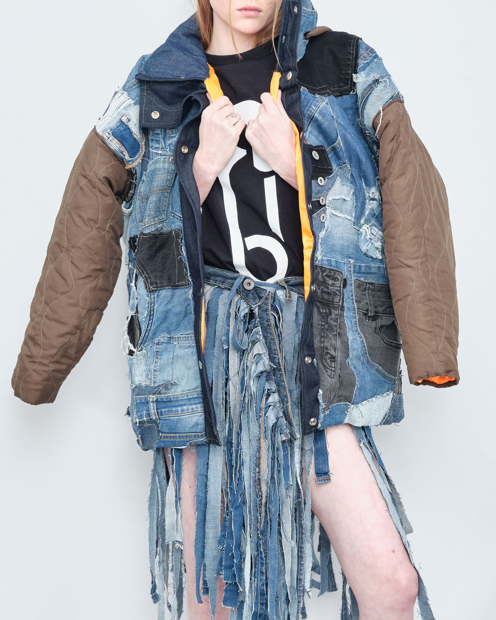 A woman wearing a denim jacket and a skirt with the number 6 on it