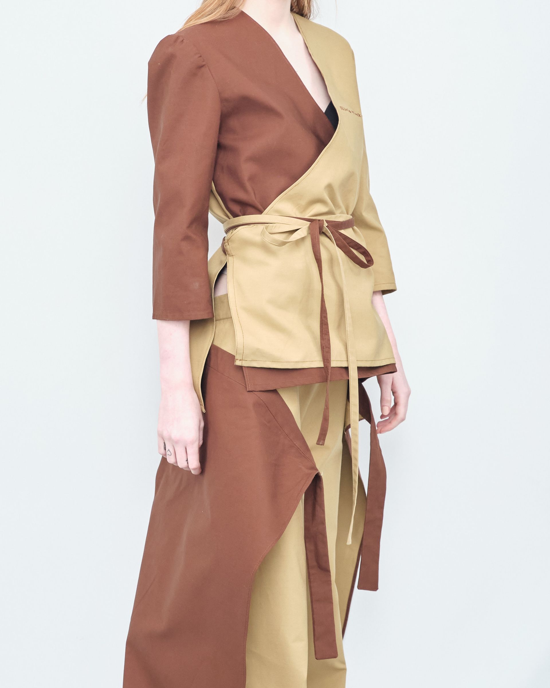 A woman is wearing a brown and tan dress